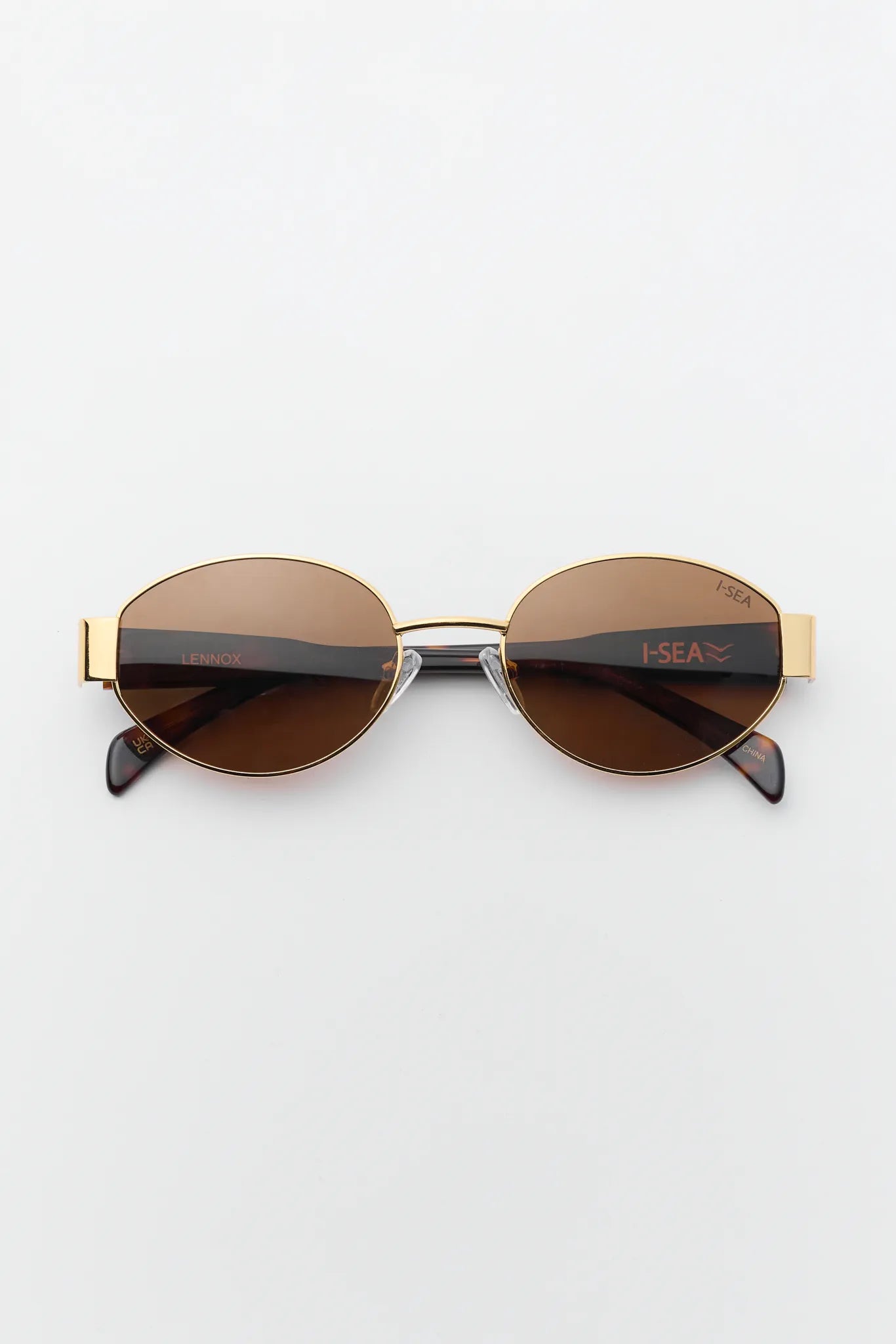 Sunglasses with gold frame and brown lenses on a white background