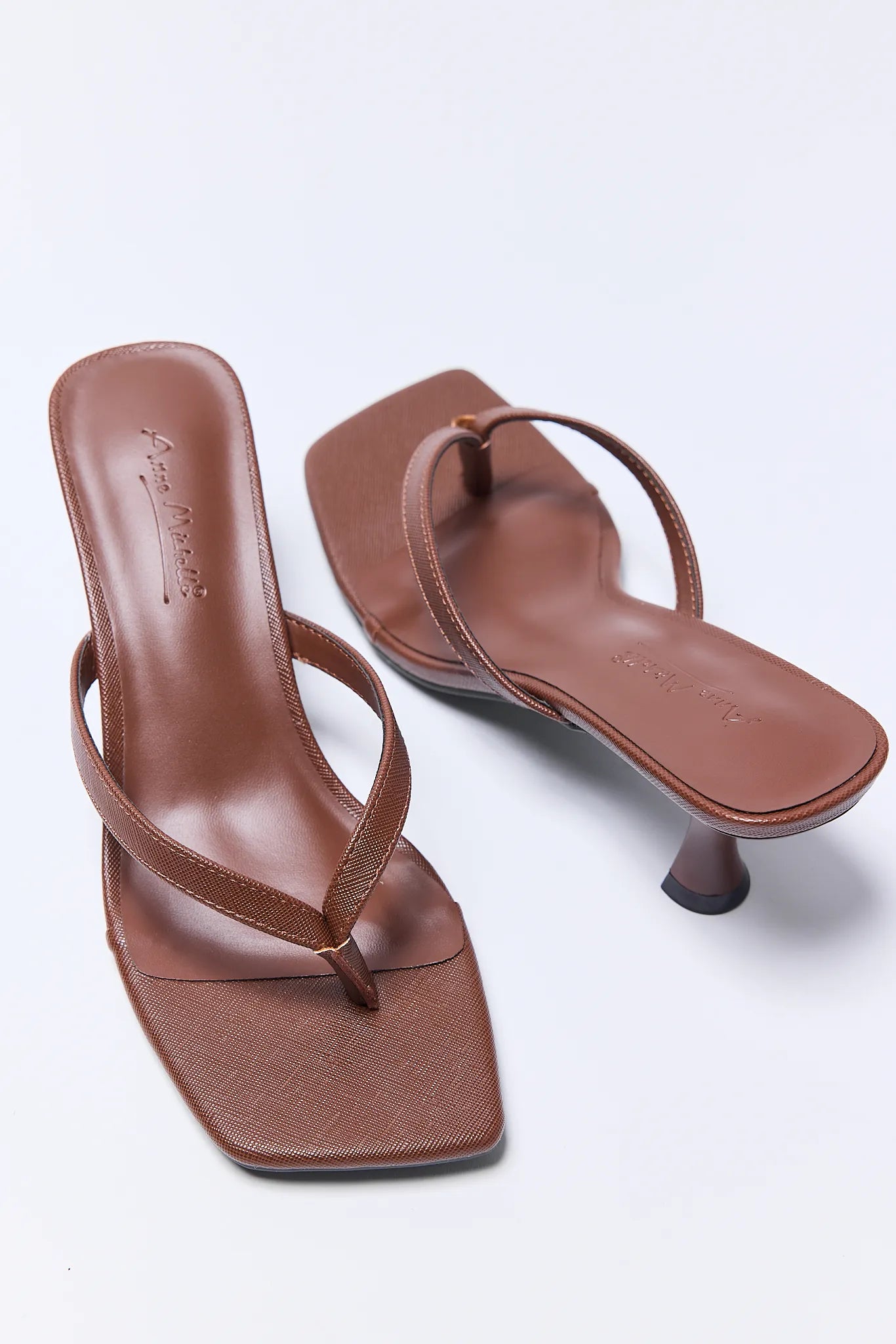 Pair of brown high-heeled Lindy Heels on a light gray background