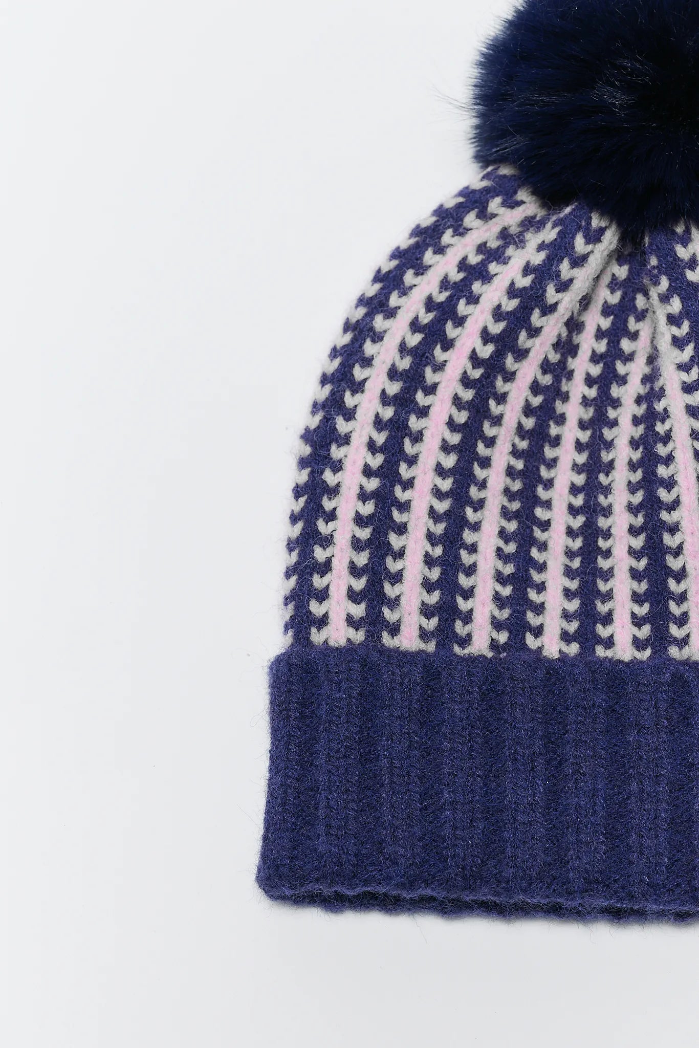 Knitted beanie with a pom-pom on a white background