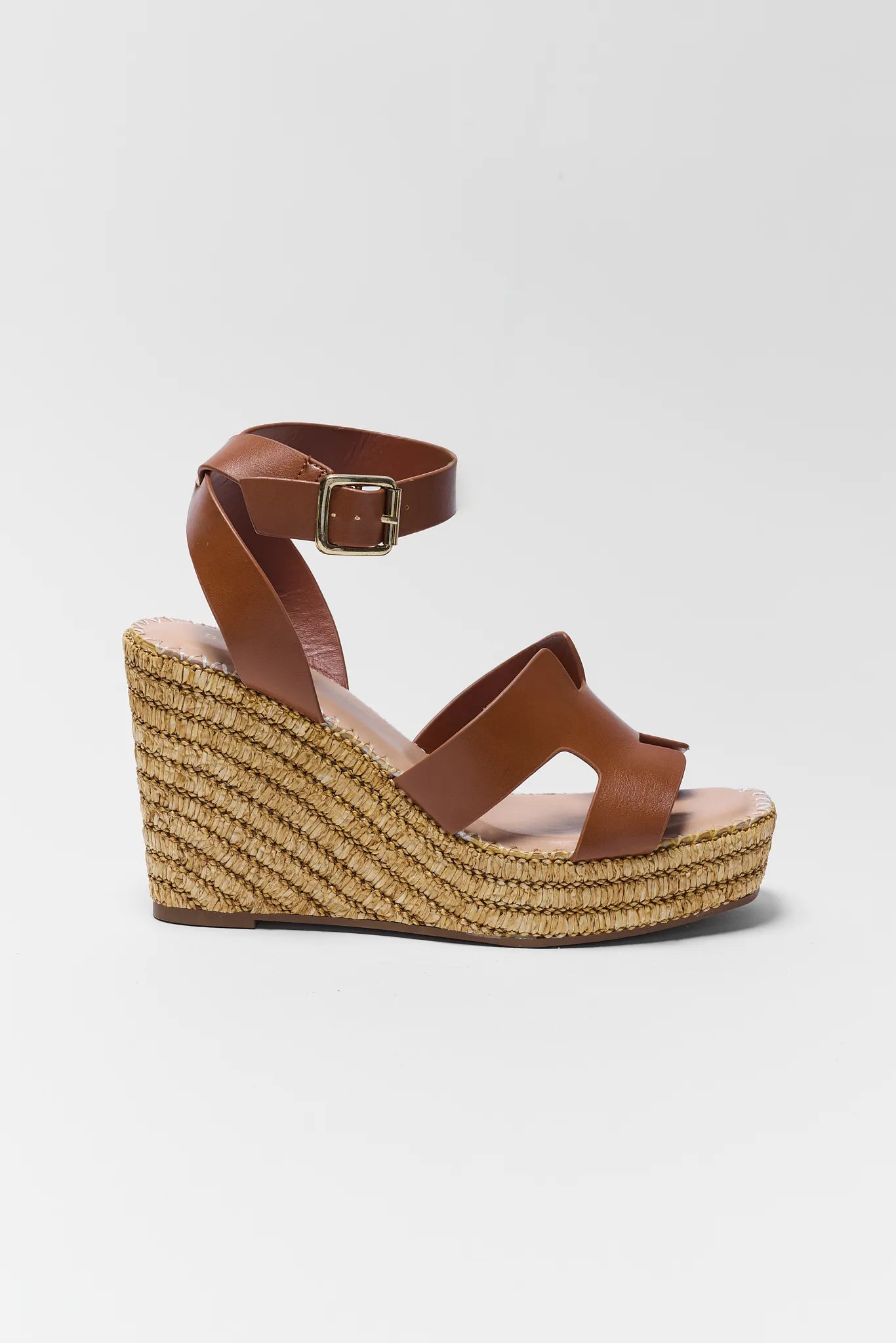 Brown wedge sandal with espadrille sole on a white background