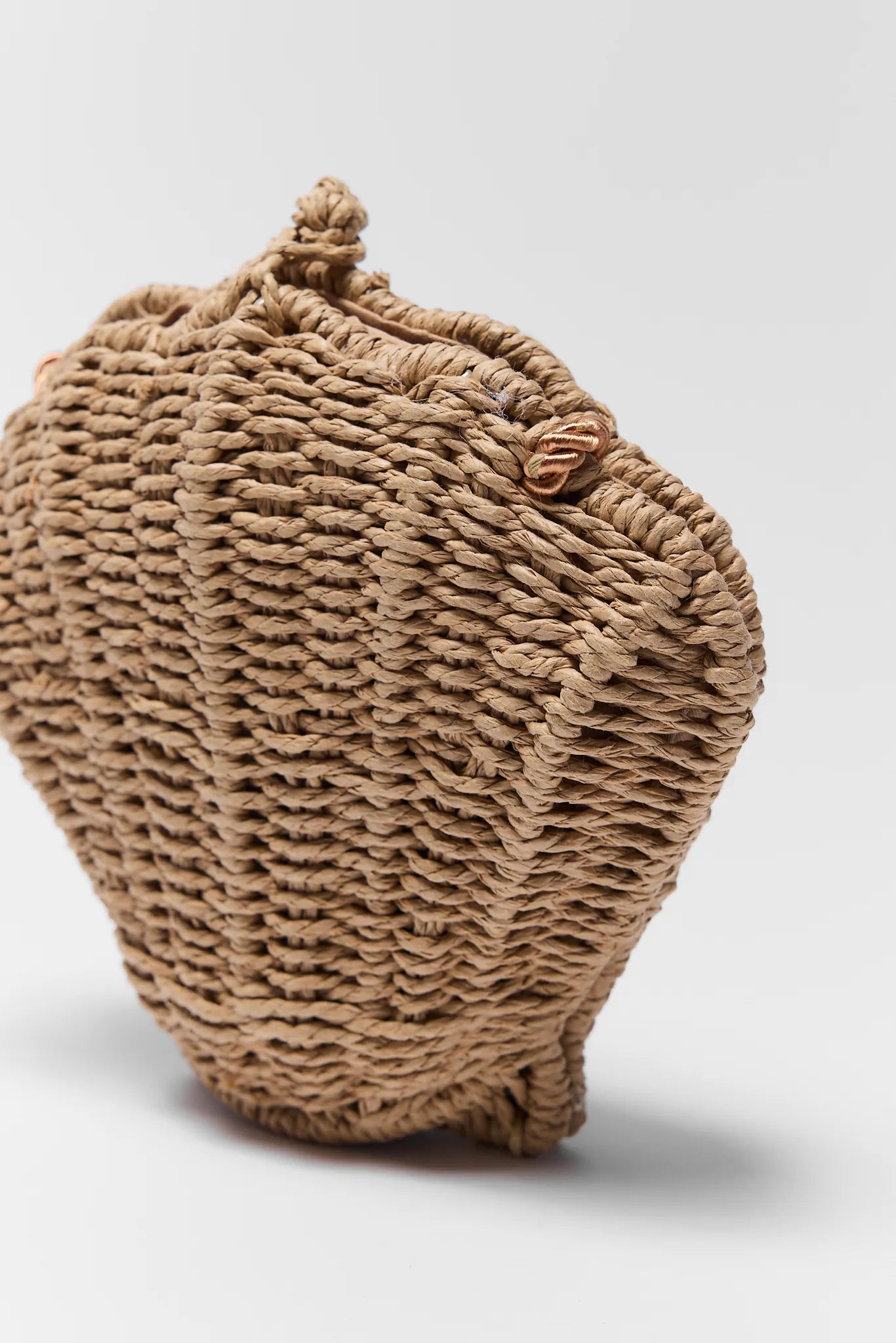 Woven basket with a textured surface on a light gray background