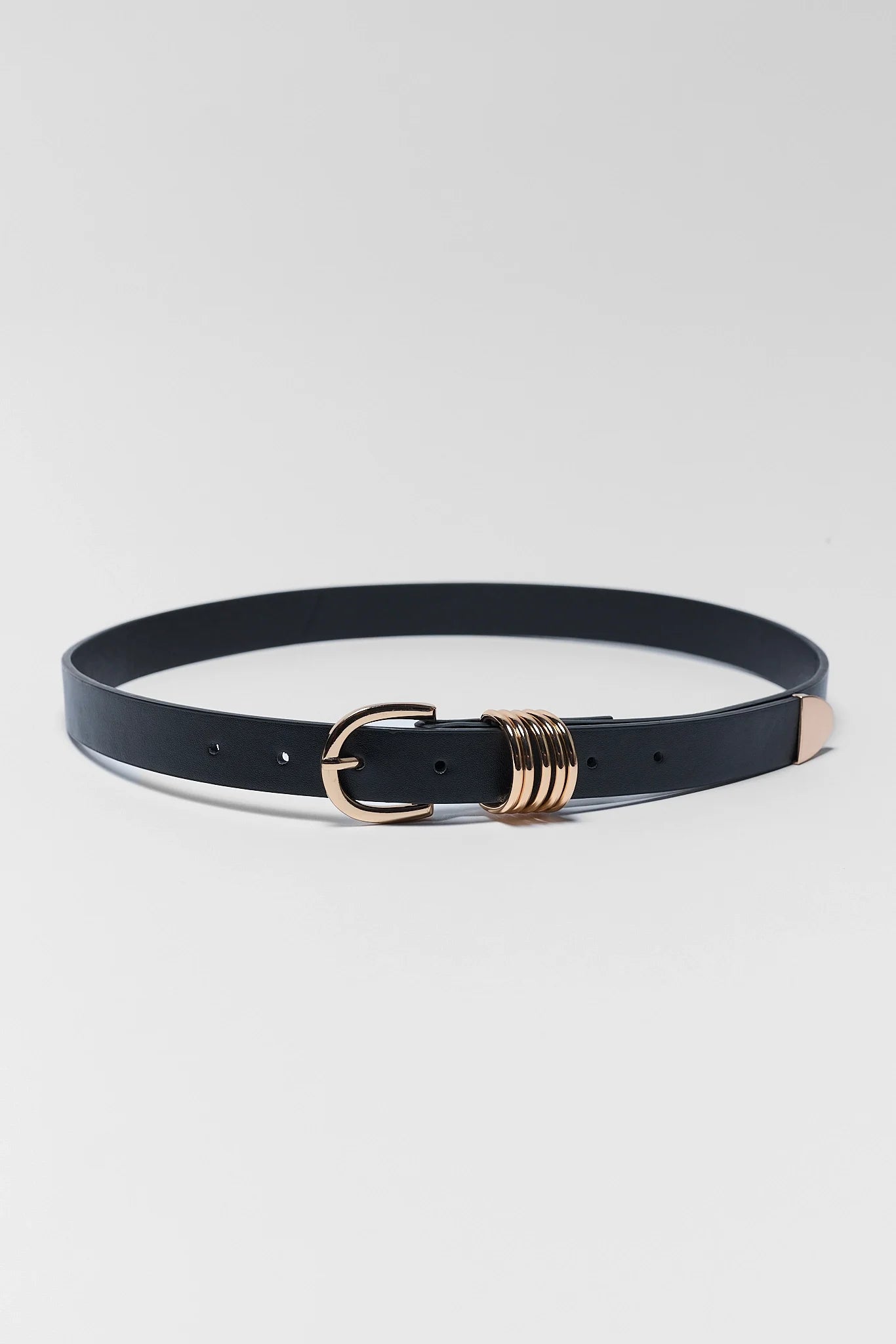 A slim black leather belt with a rose gold buckle and a decorative stack of rose gold rings near the center, displayed on a light gray background.