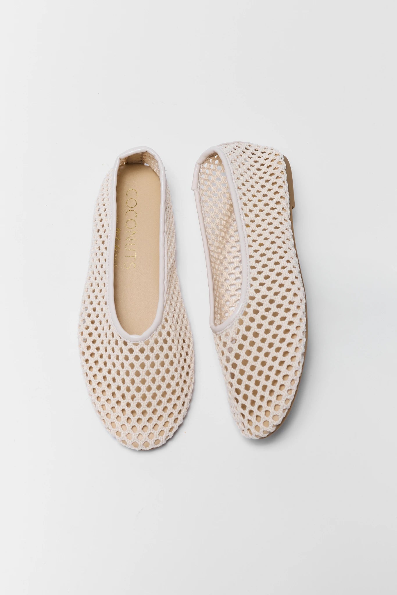 Pair of beige woven shoes on a light gray background