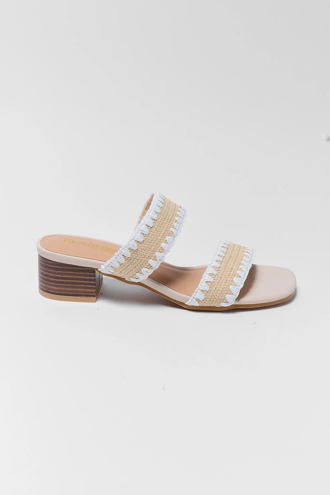one Beige sandal with white raffia straps on a light gray background