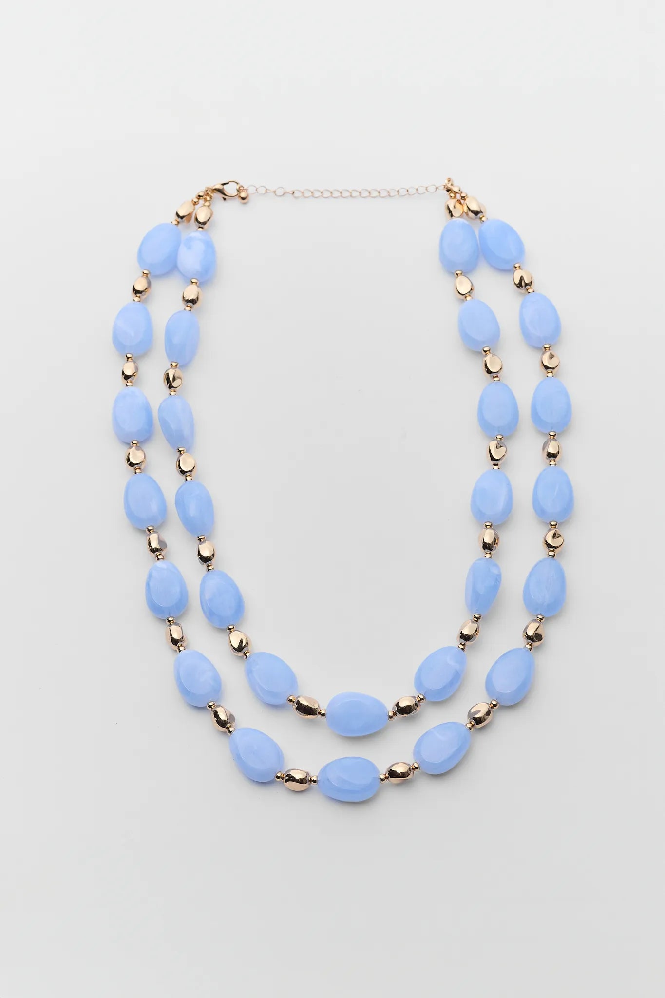 Two-layered blue beaded necklace on a light gray background
