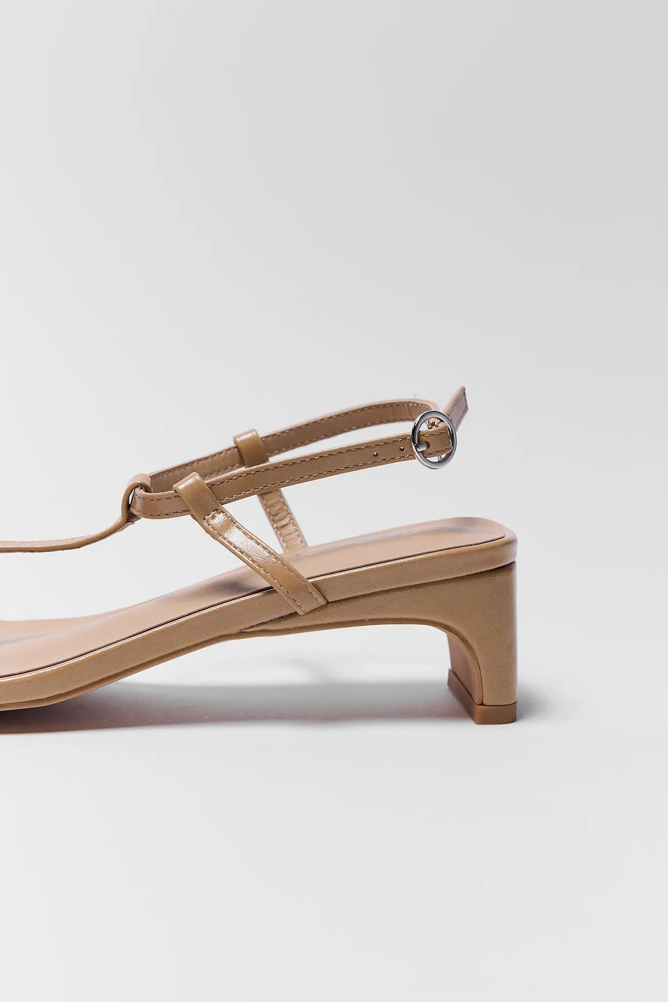Beige sandal with a block heel on a light gray background
