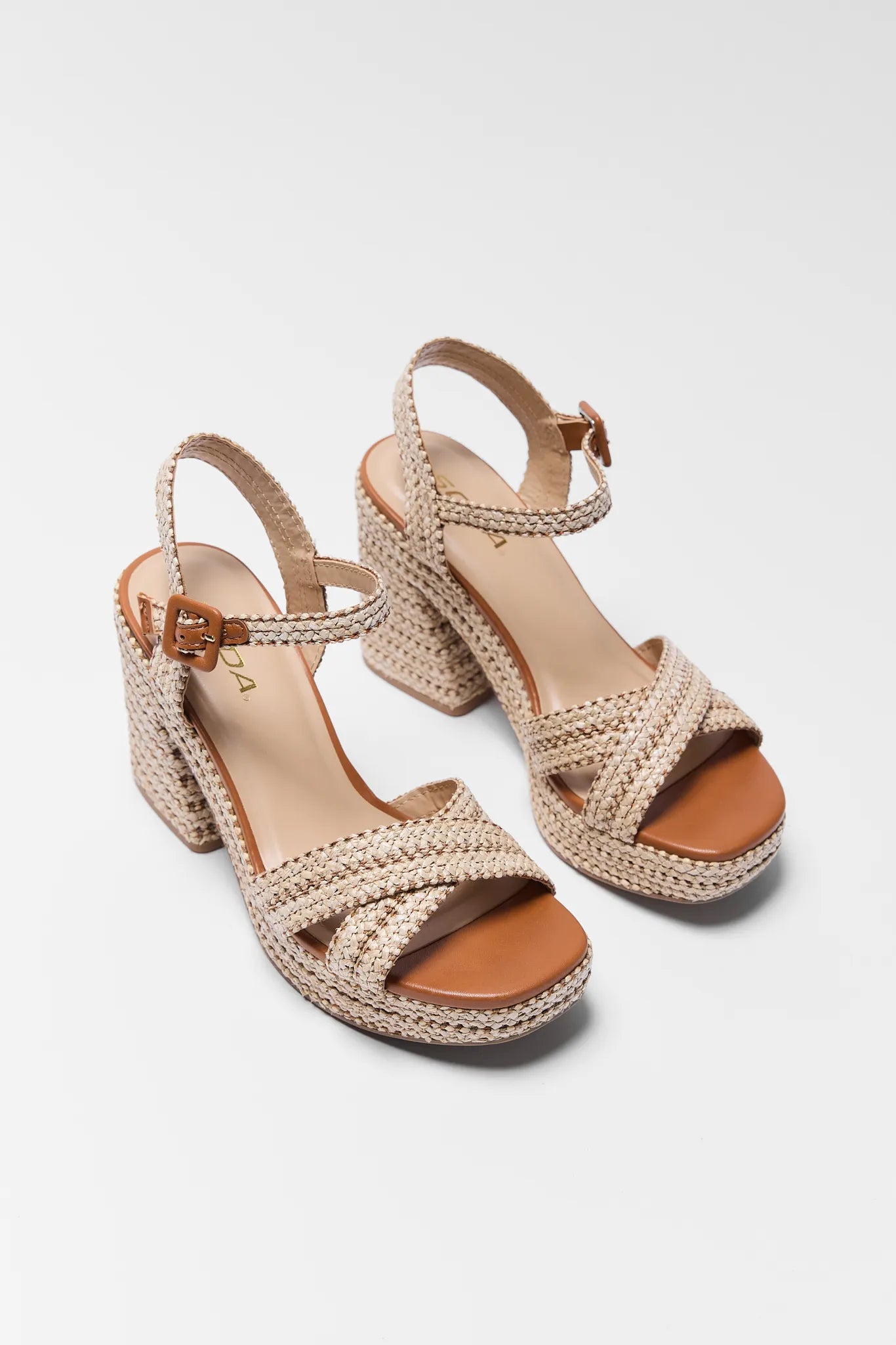 Pair of Millie Raffia Platform Heels with brown soles on a light gray background
