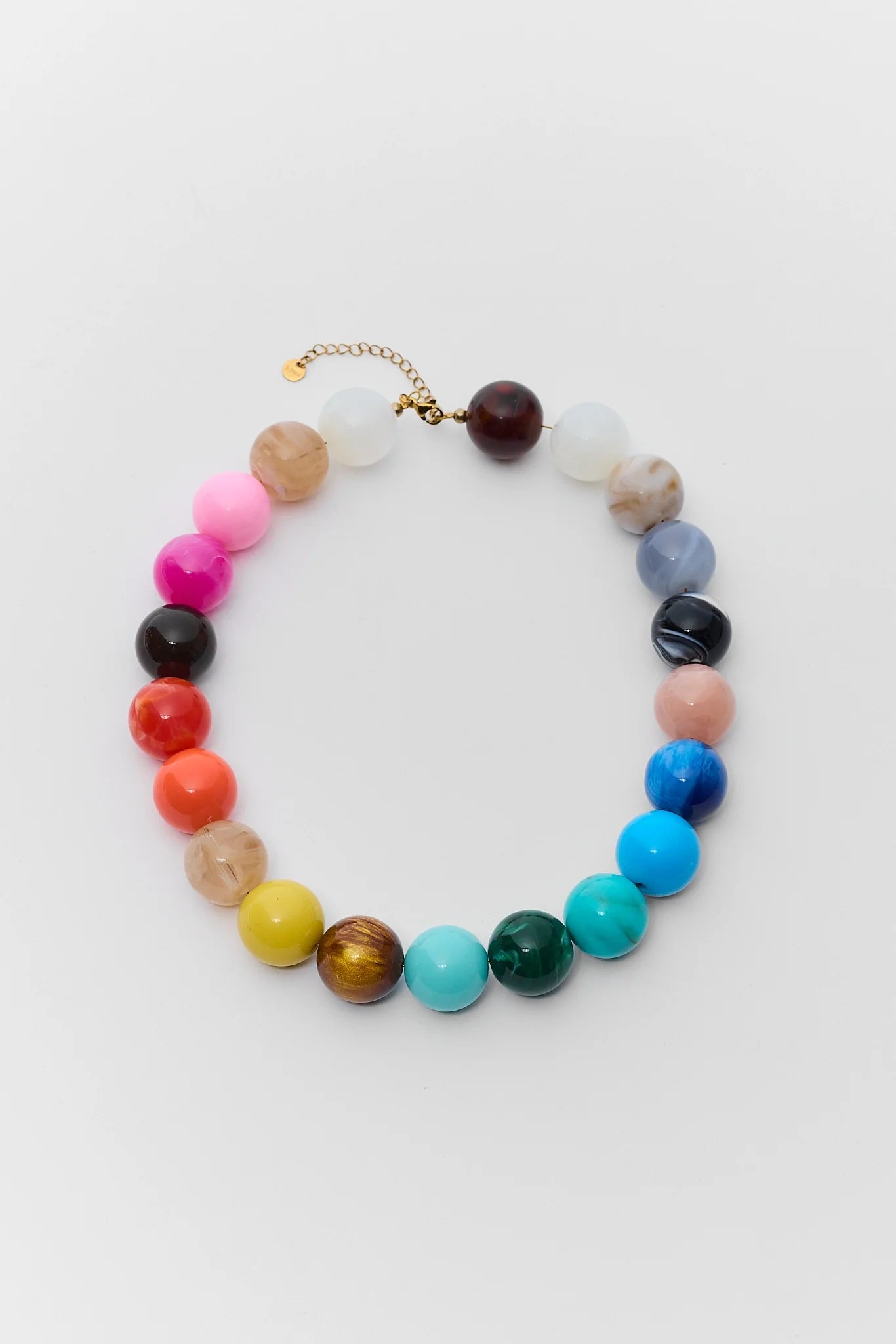 A multicolor beaded necklace with faceted round beads in various colors including pink, red, orange, yellow, green, blue, and white, arranged in a circle on a light gray background.