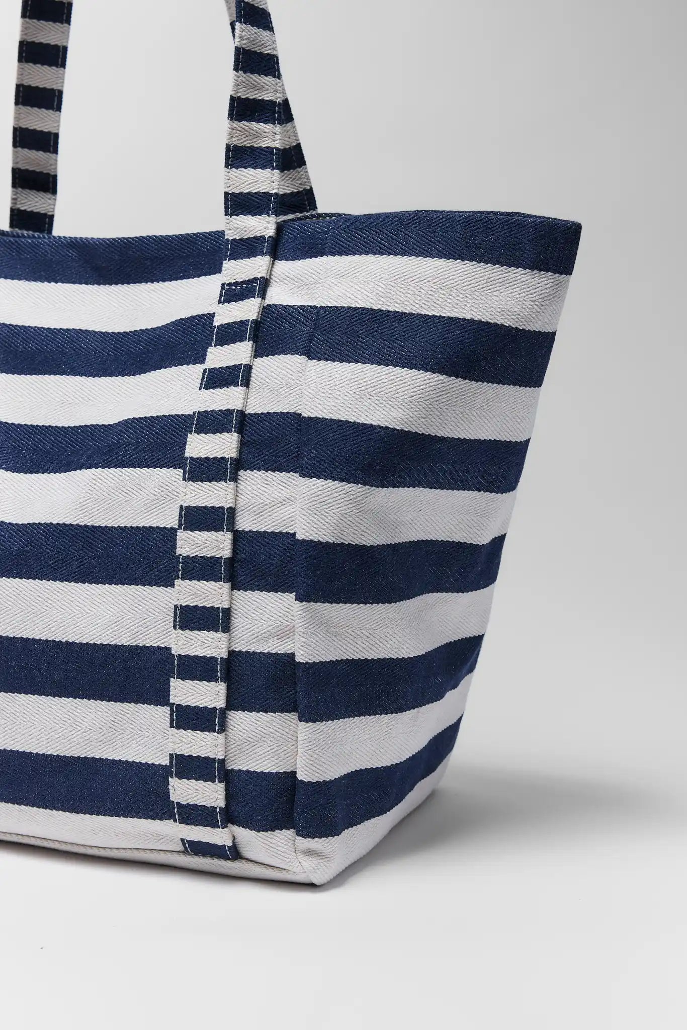 close up Blue and white striped tote bag on a light gray background