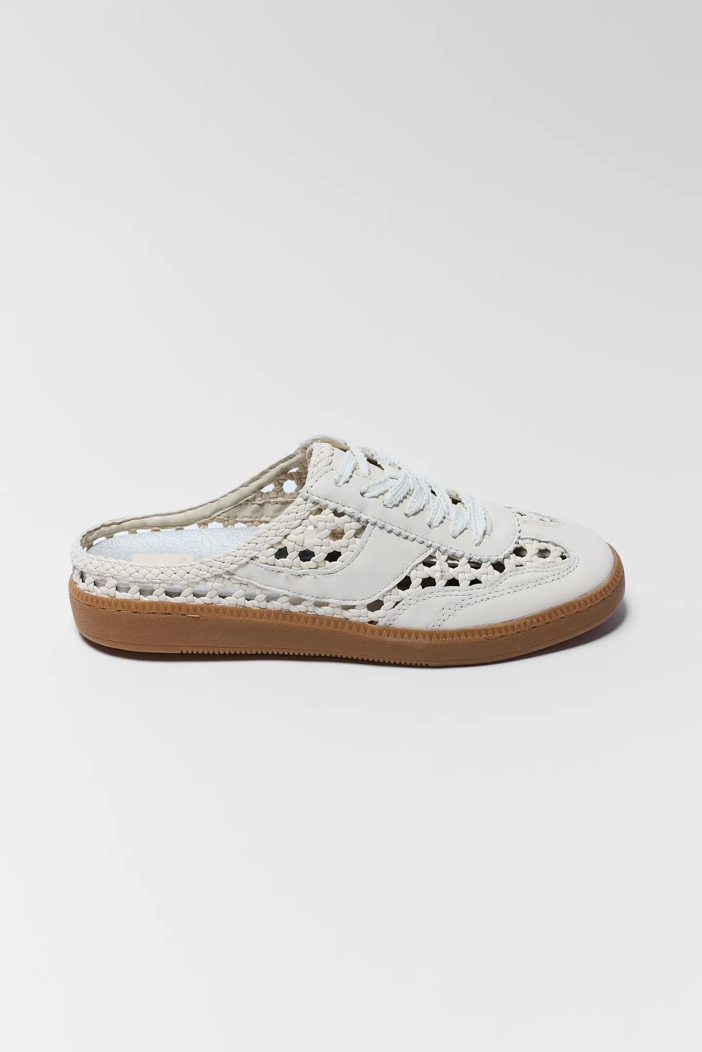 White sneaker with brown sole on a light gray background