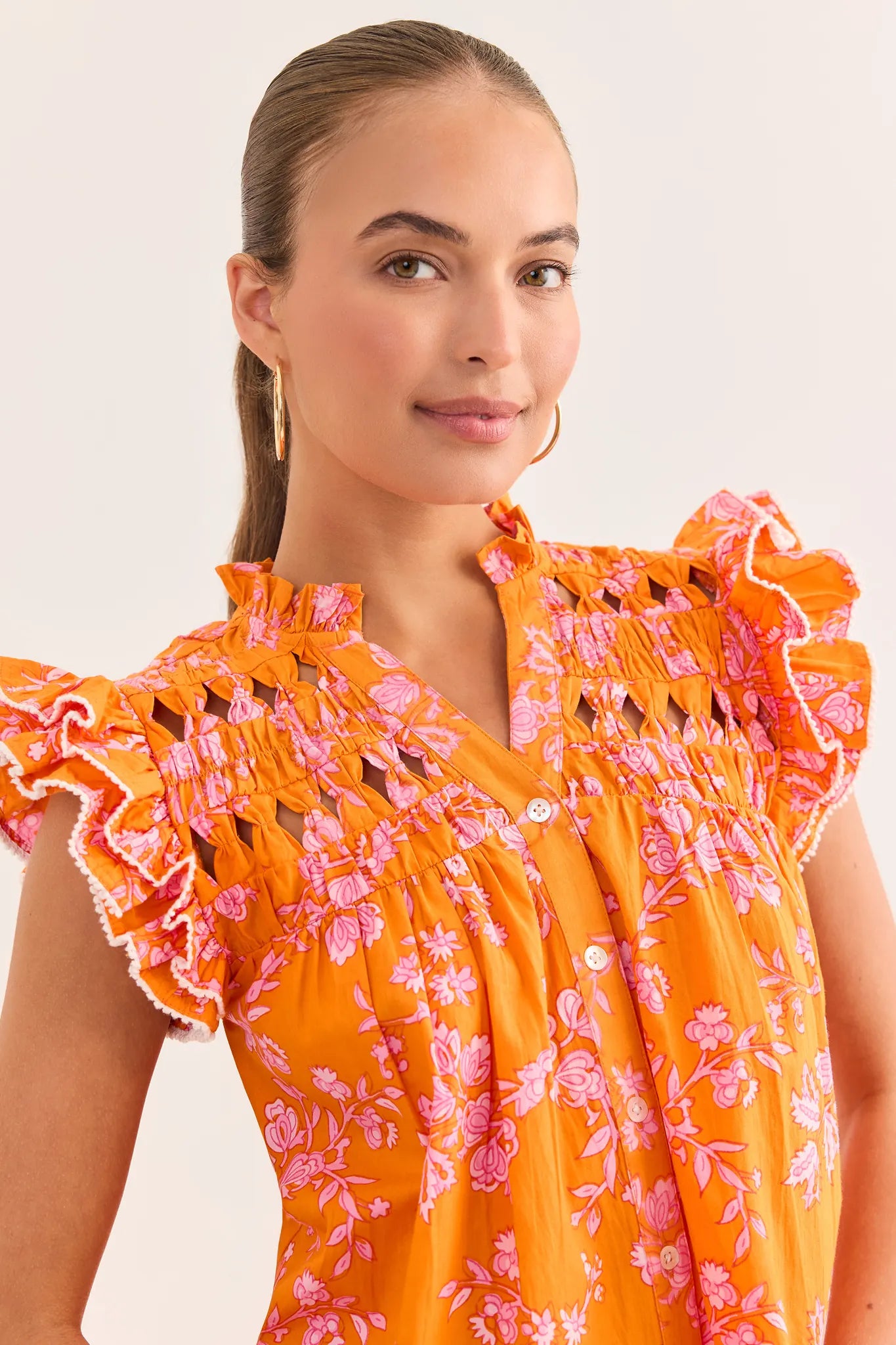 close up Woman wearing an orange floral dress with a plain background