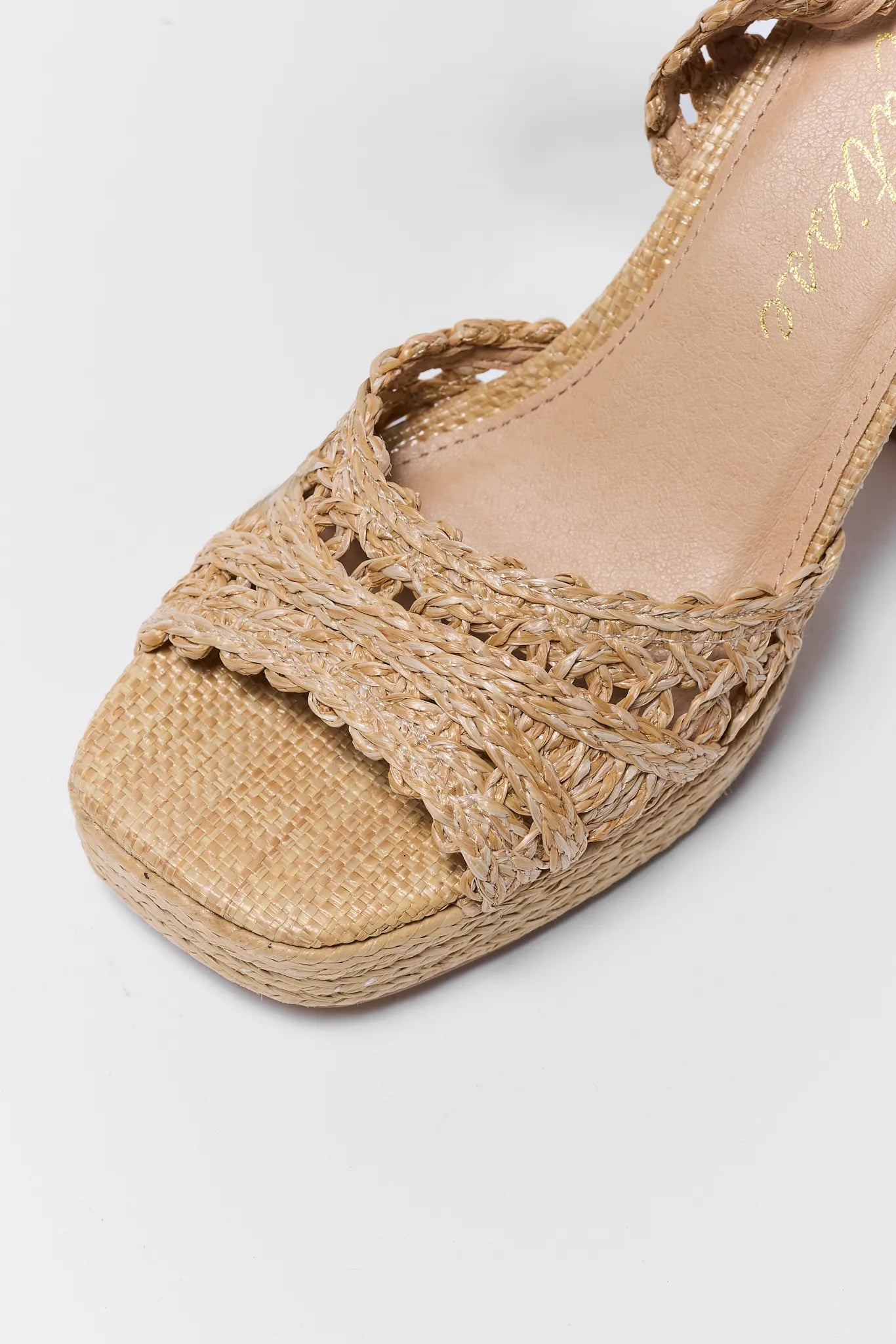 close up Beige sandal with woven design on a white background