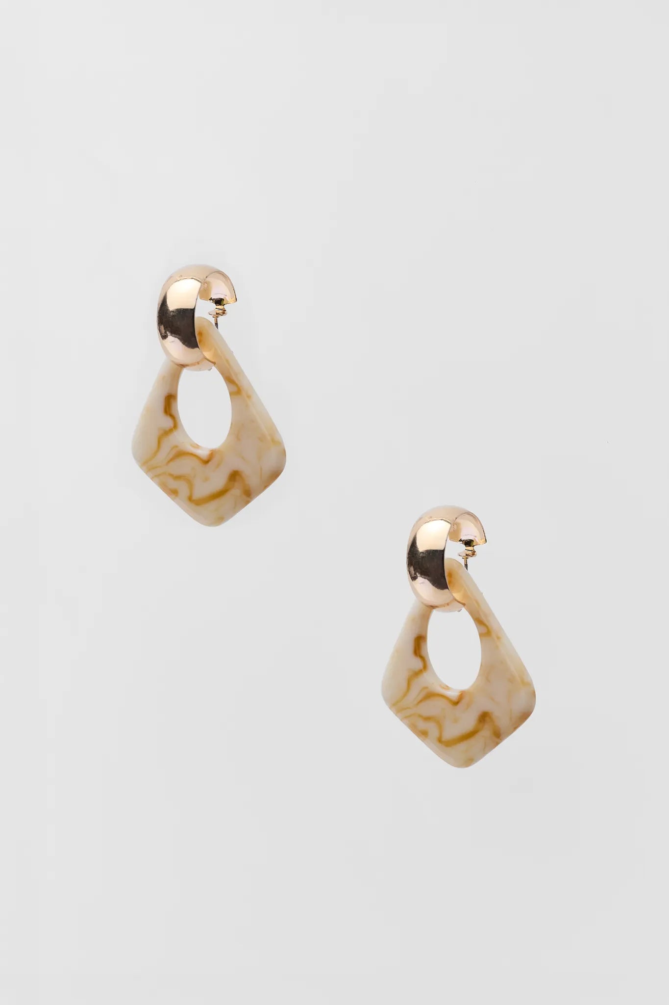 Pair of gold earrings on a light gray background