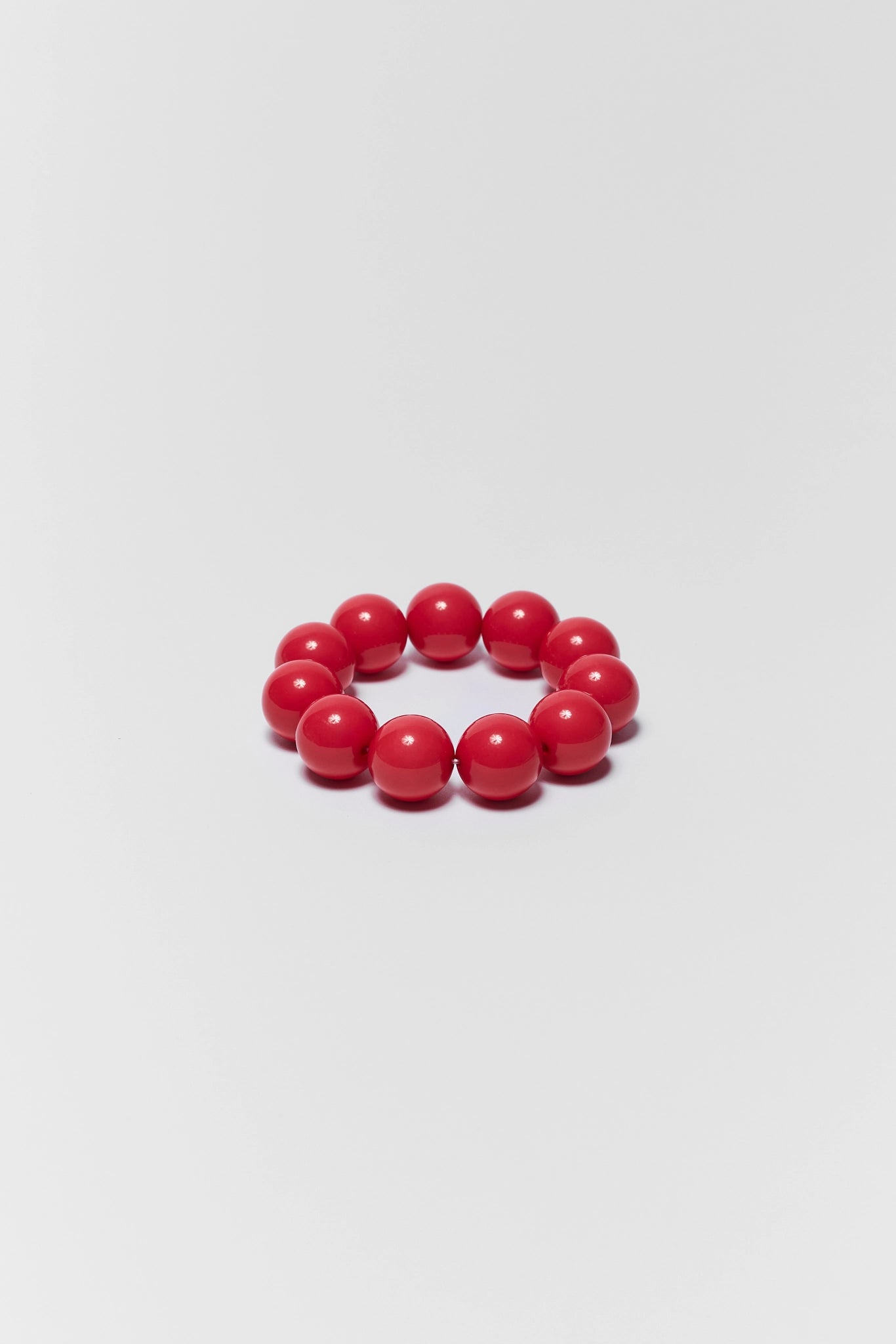 Red beaded bracelet on a light gray background