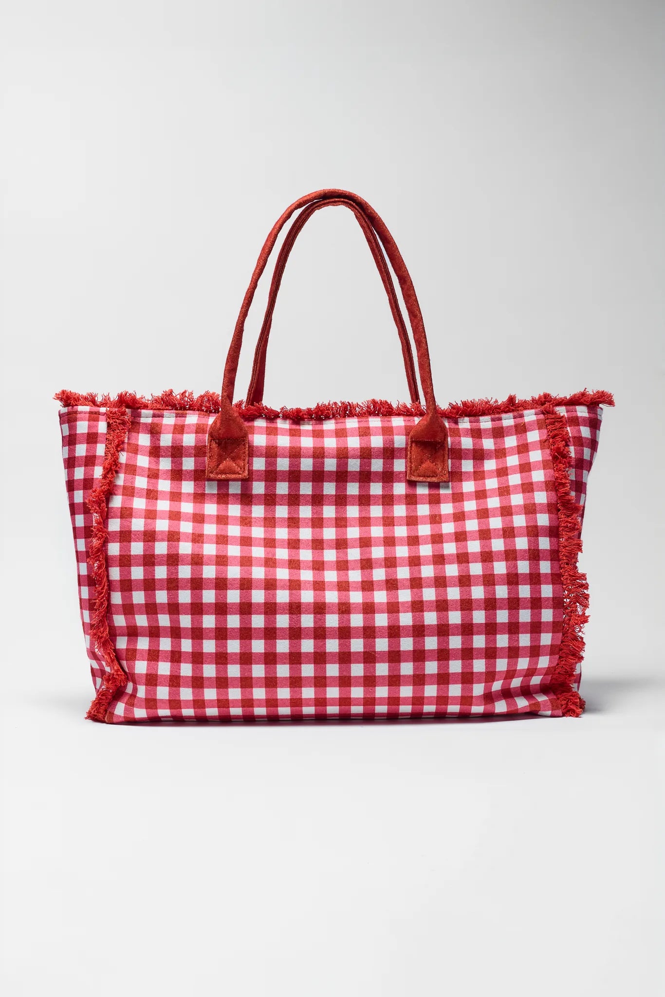 Red and white checkered bag with fringes on a light gray background