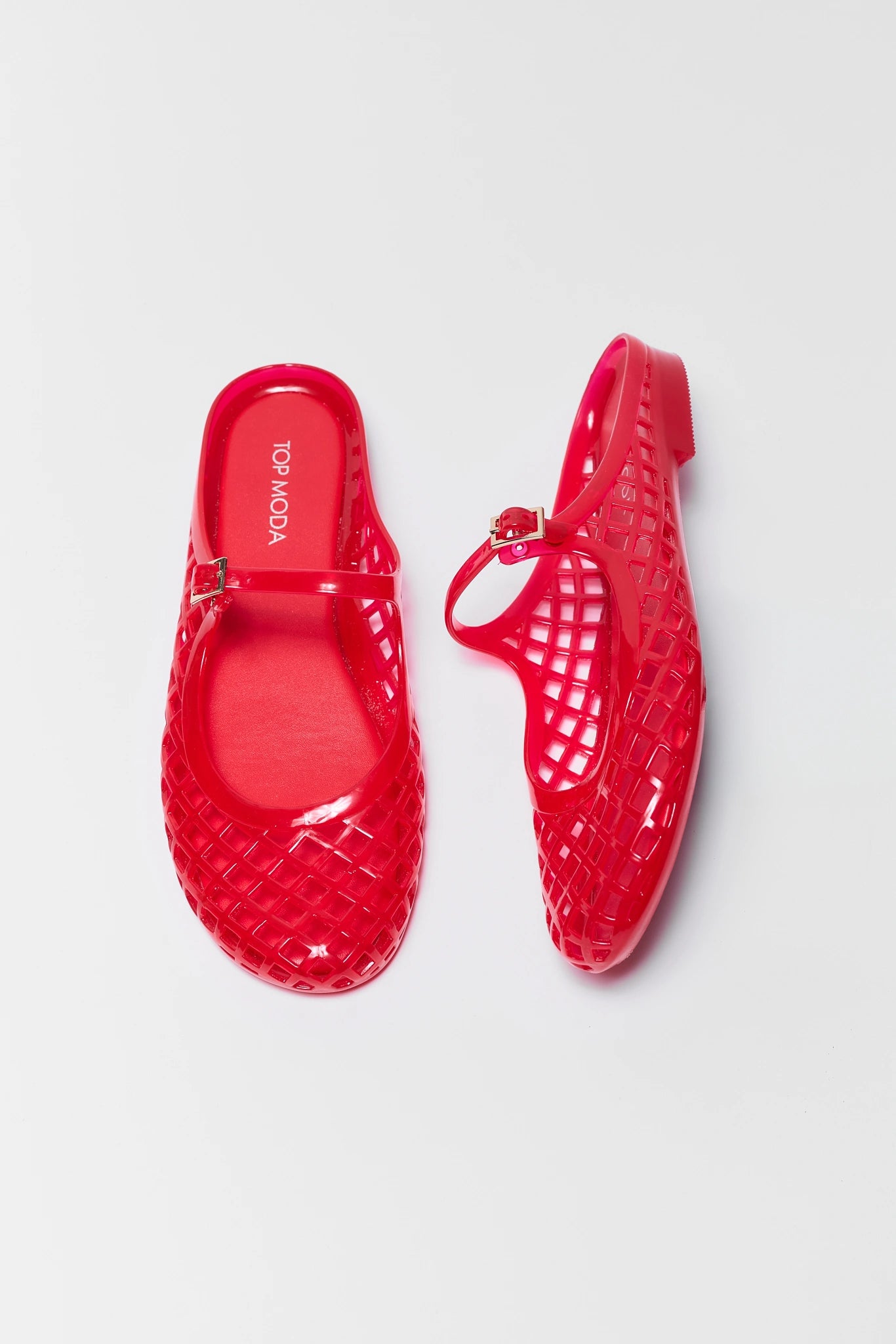 Red jelly shoes on a light gray background