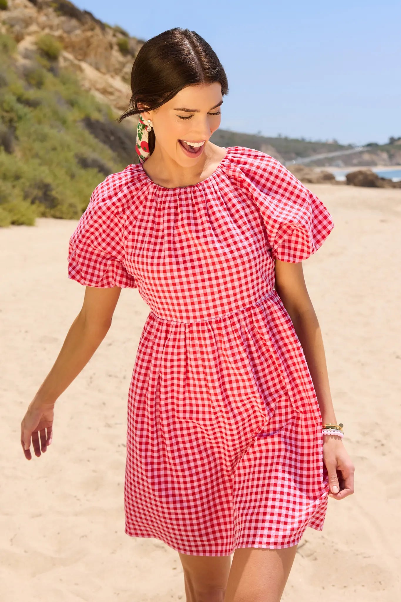 Woman in a red and white checkered dress on a beach
