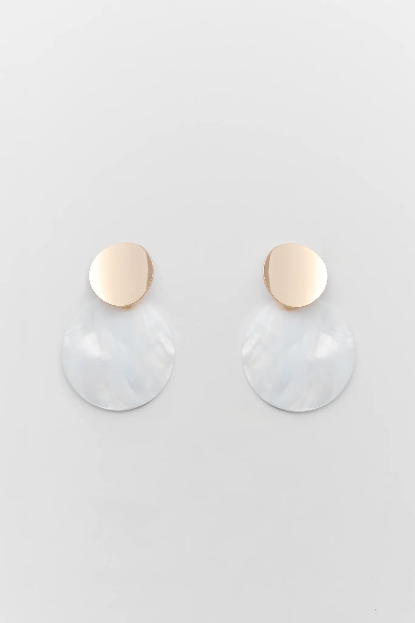 Pair of earrings with gold and clear components on a light gray background
