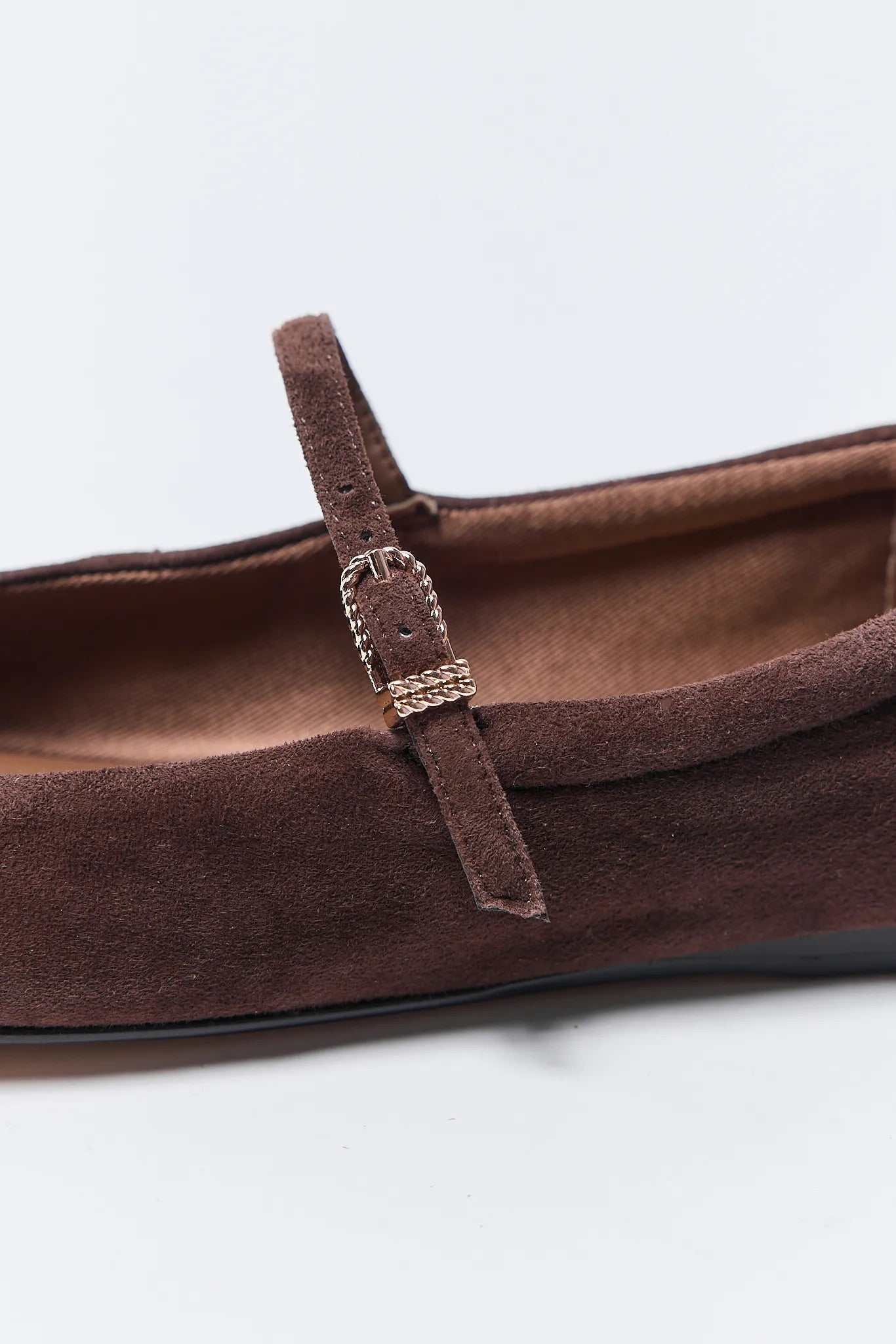 Brown flat Reyes Ballet Flats with a strap on a light gray background