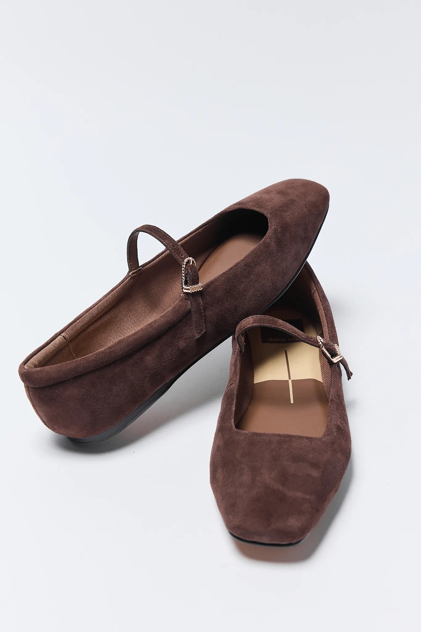 Pair of brown suede Reyes Ballet Flats on a light gray background