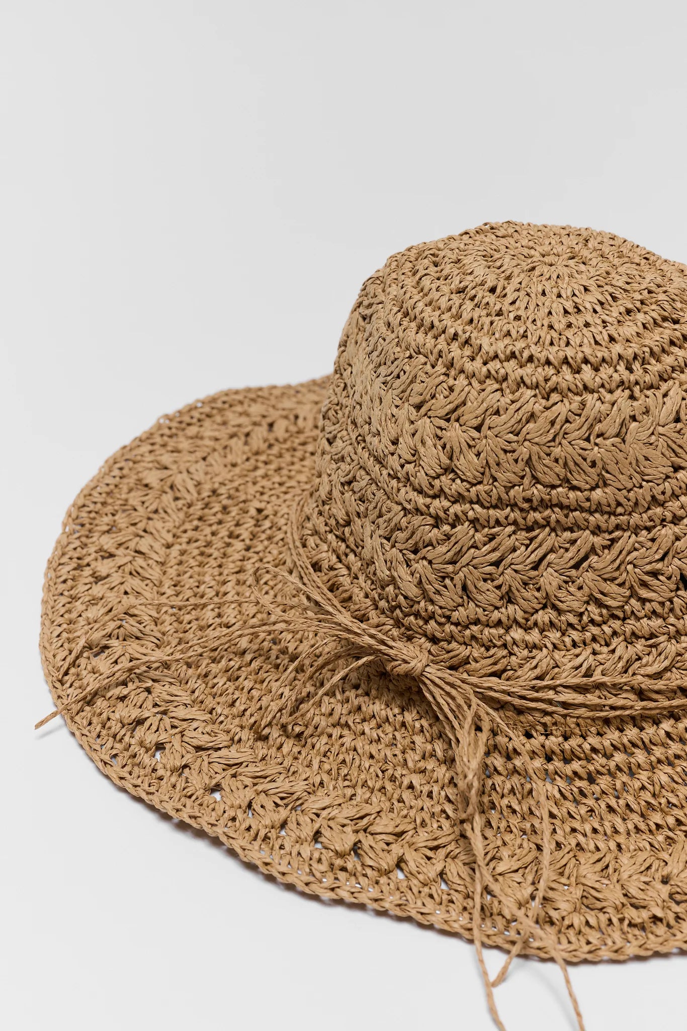 Brown woven sun hat on a light gray background