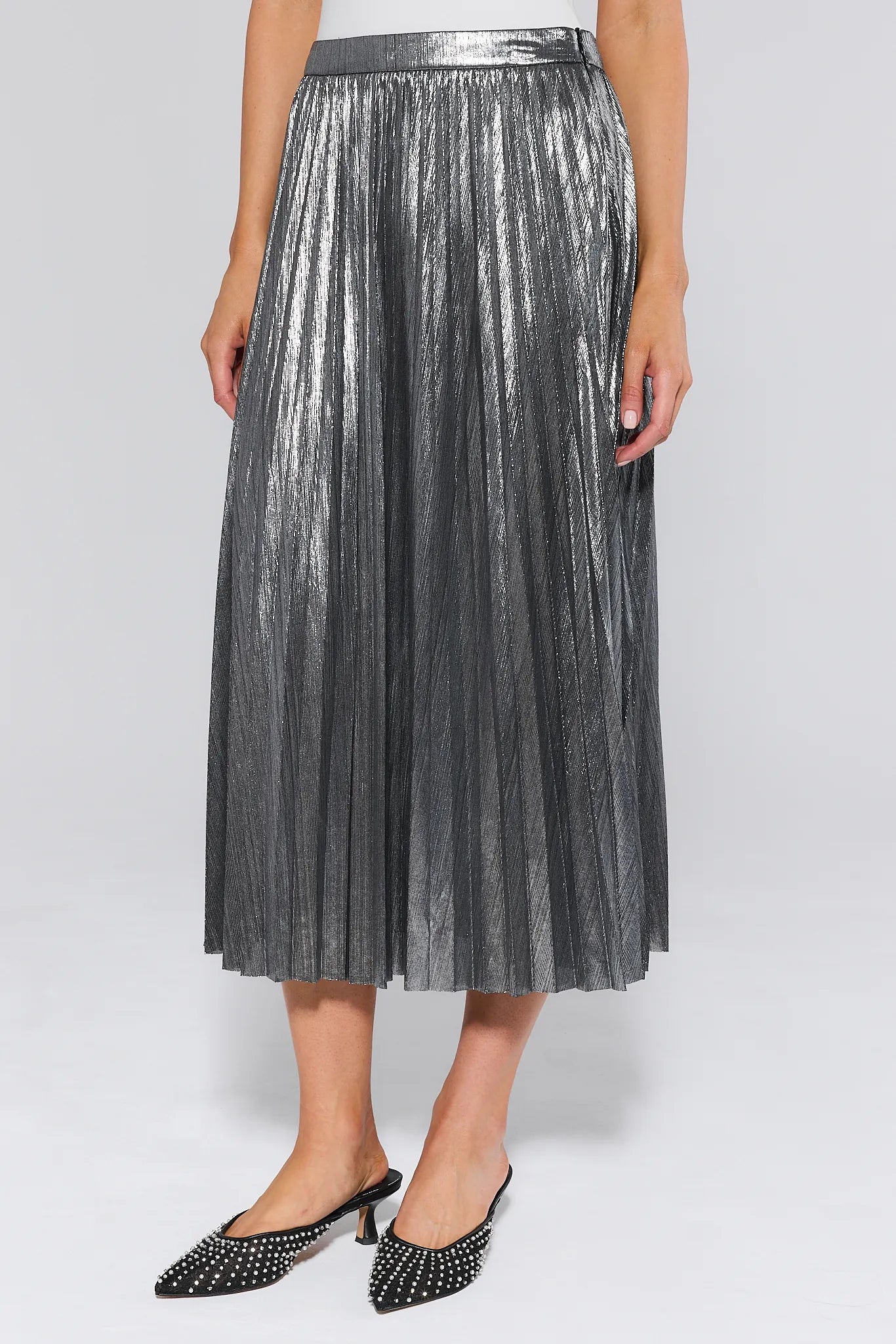 Person wearing a metallic Hensley Silver Pleated Midi Skirt on a white background