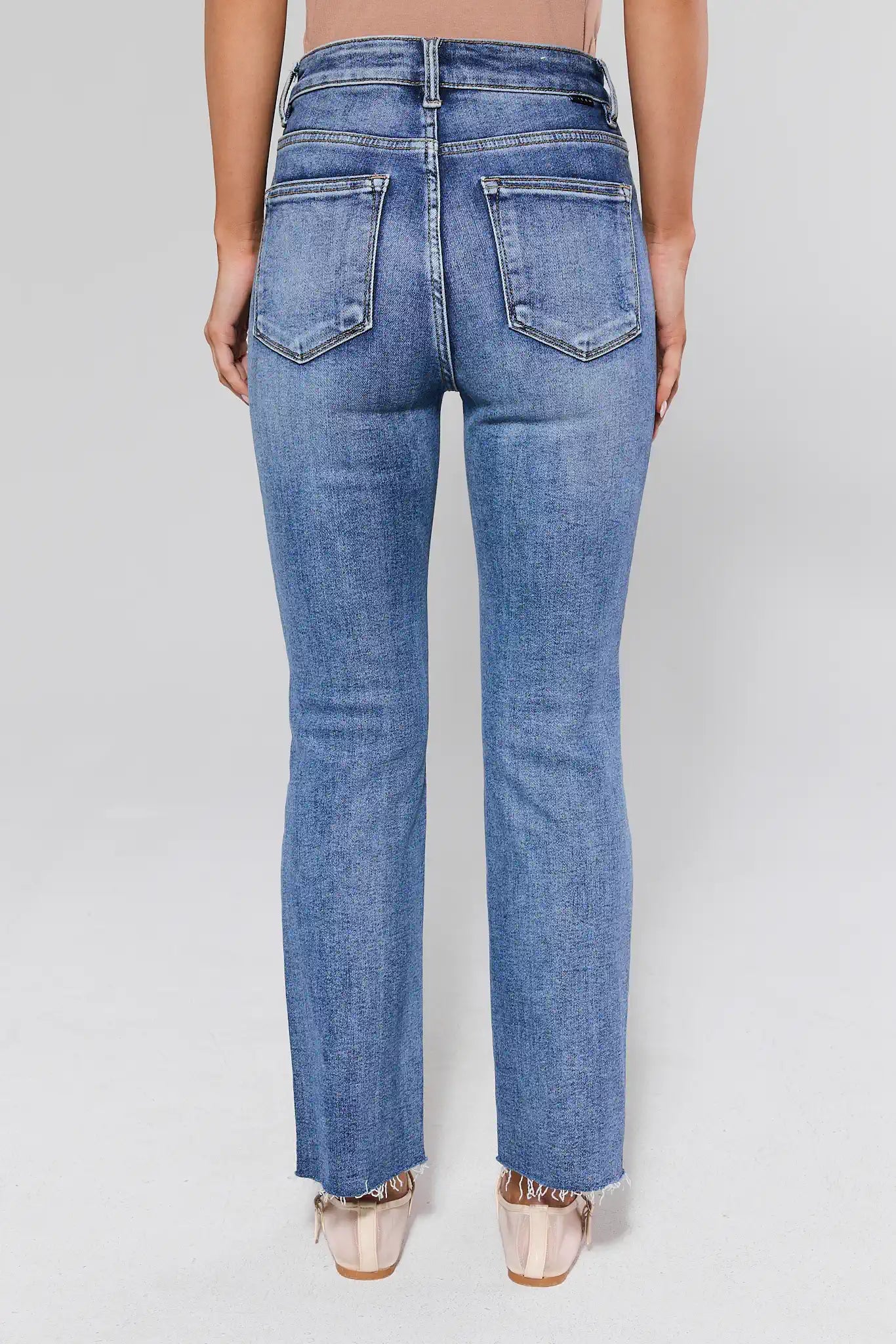 Blue jeans worn by a person on a white background