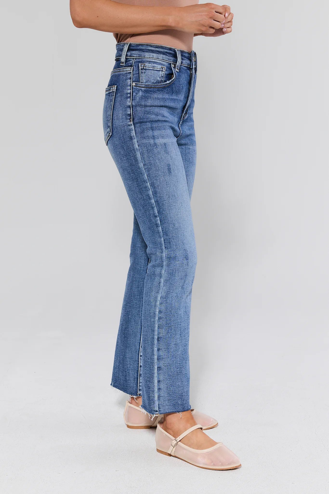 Blue jeans worn by a person on a white background