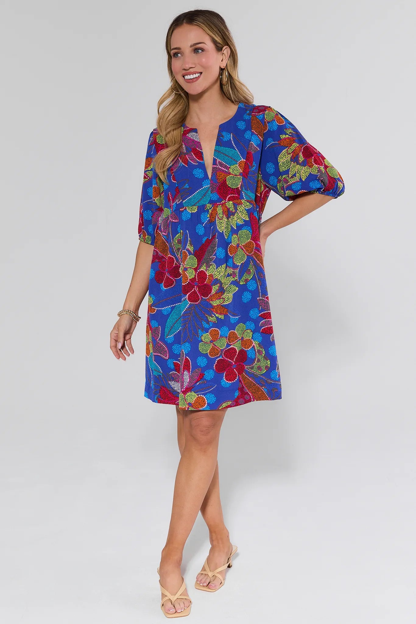 Woman wearing a colorful floral dress on a white background