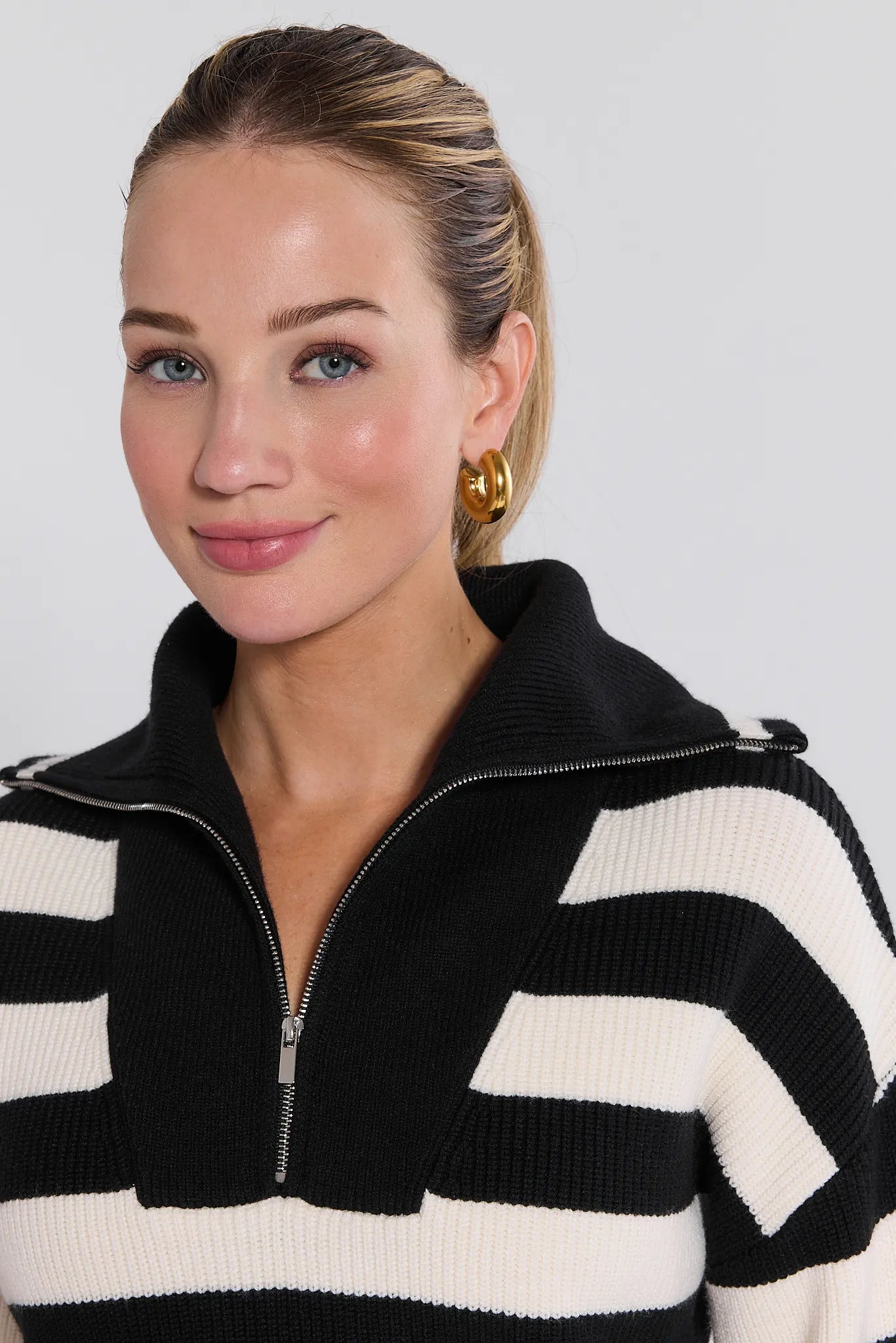 Woman wearing a black and white striped Cheryl Sweater against a plain background