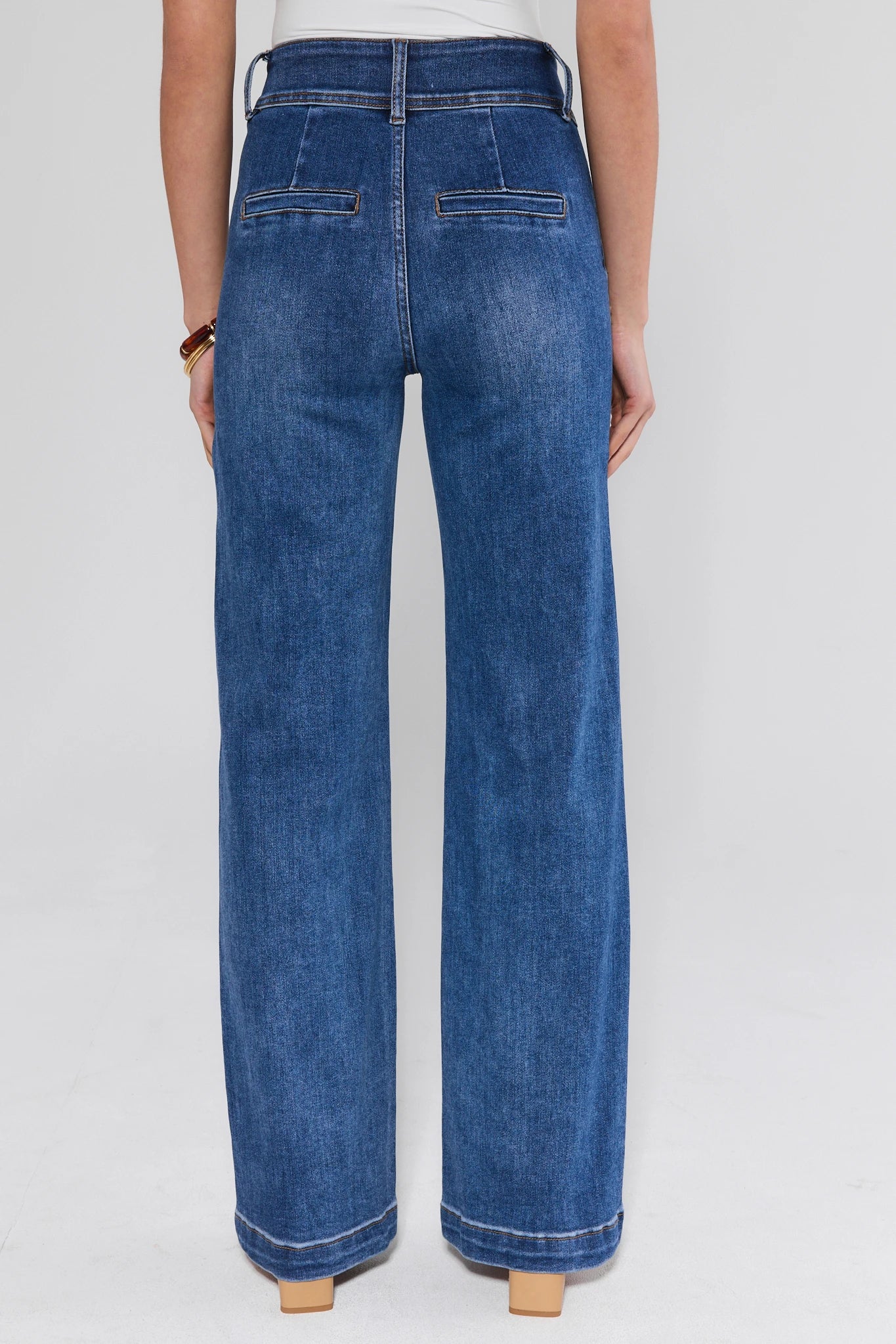 Blue jeans worn by a person on a white background