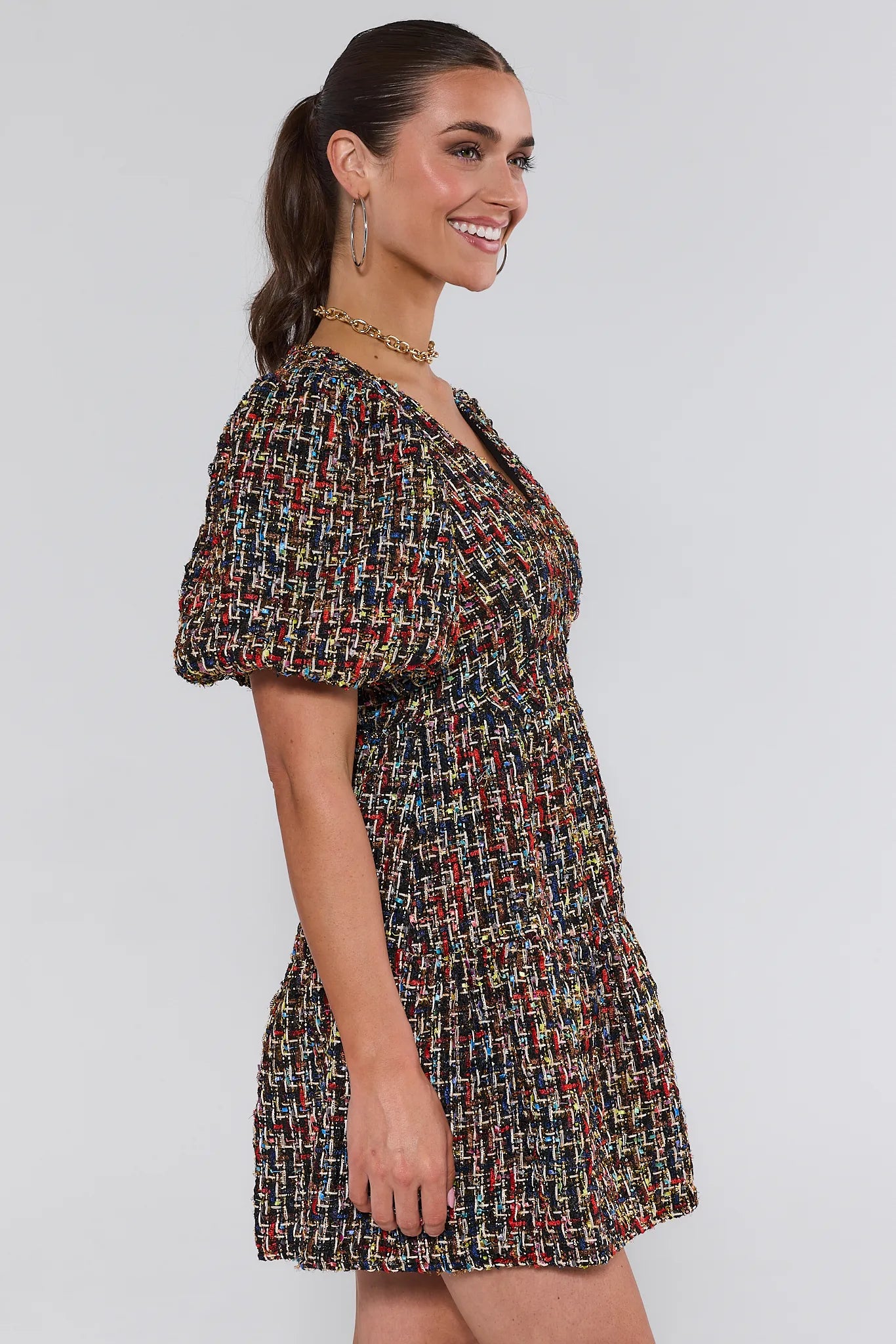 Woman wearing a patterned Cindy Multi Tweed Mini Dress against a plain background