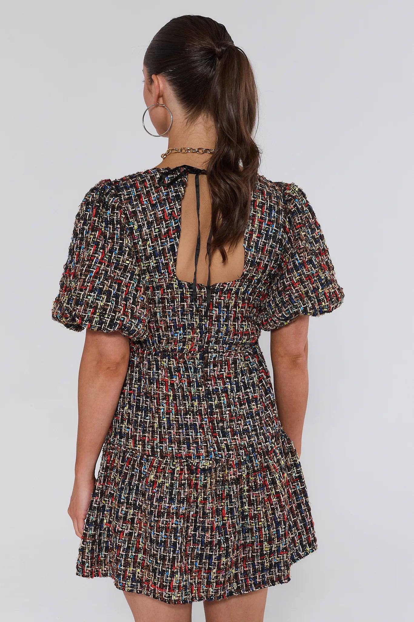 Woman wearing a patterned Cindy Multi Tweed Mini Dress against a plain background