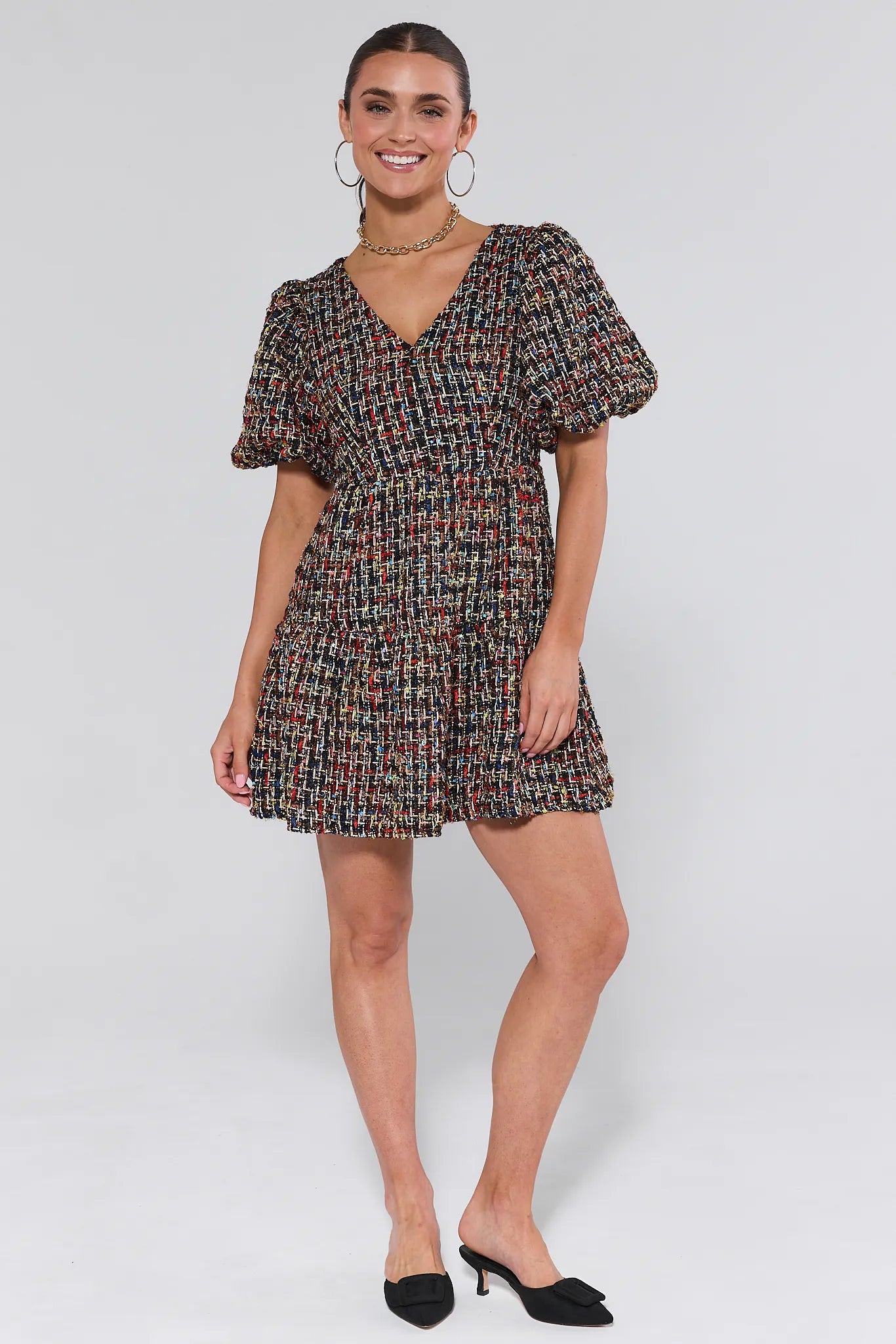 Woman wearing a patterned Cindy Multi Tweed Mini Dress against a plain background