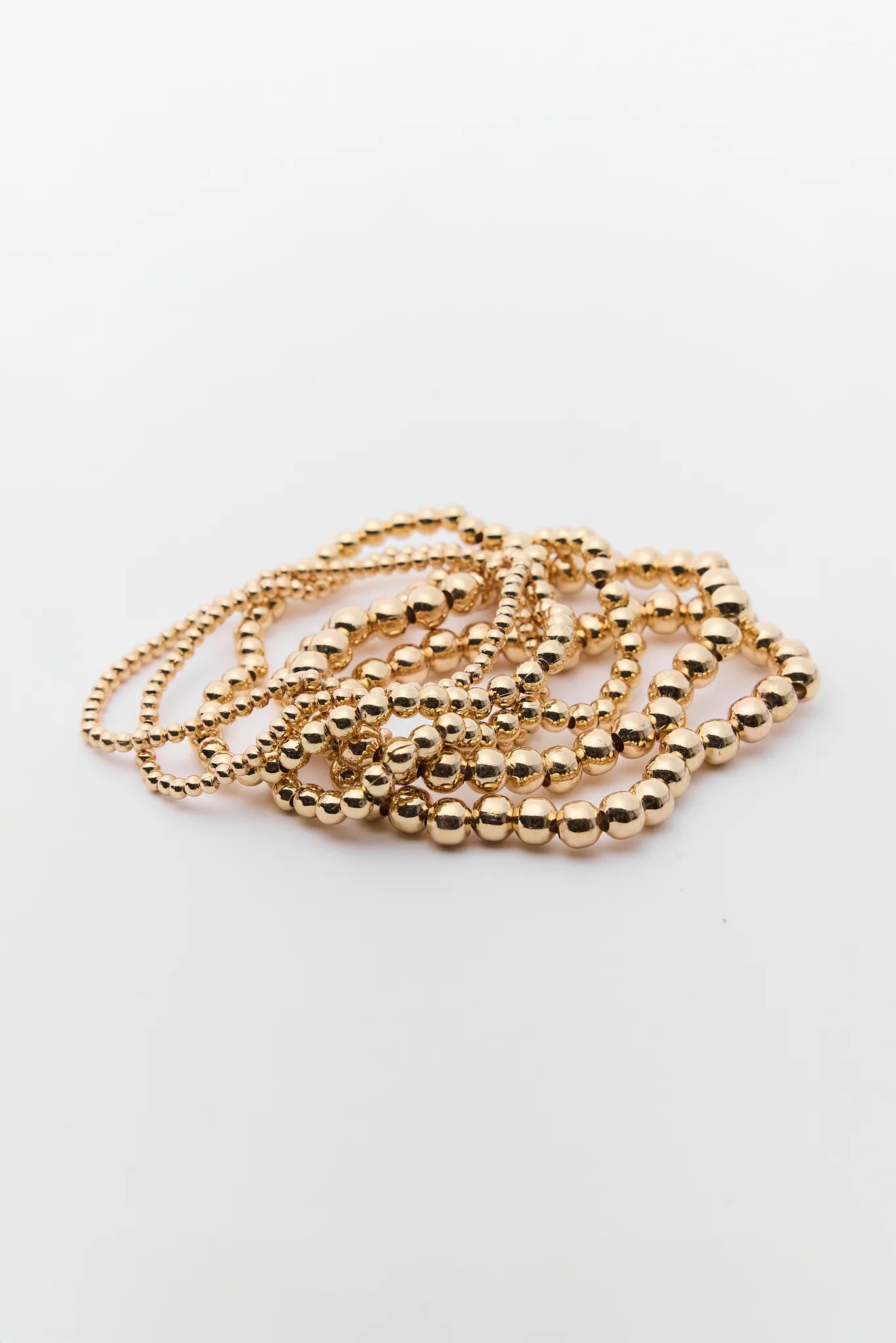 Gold beaded necklace on a white background