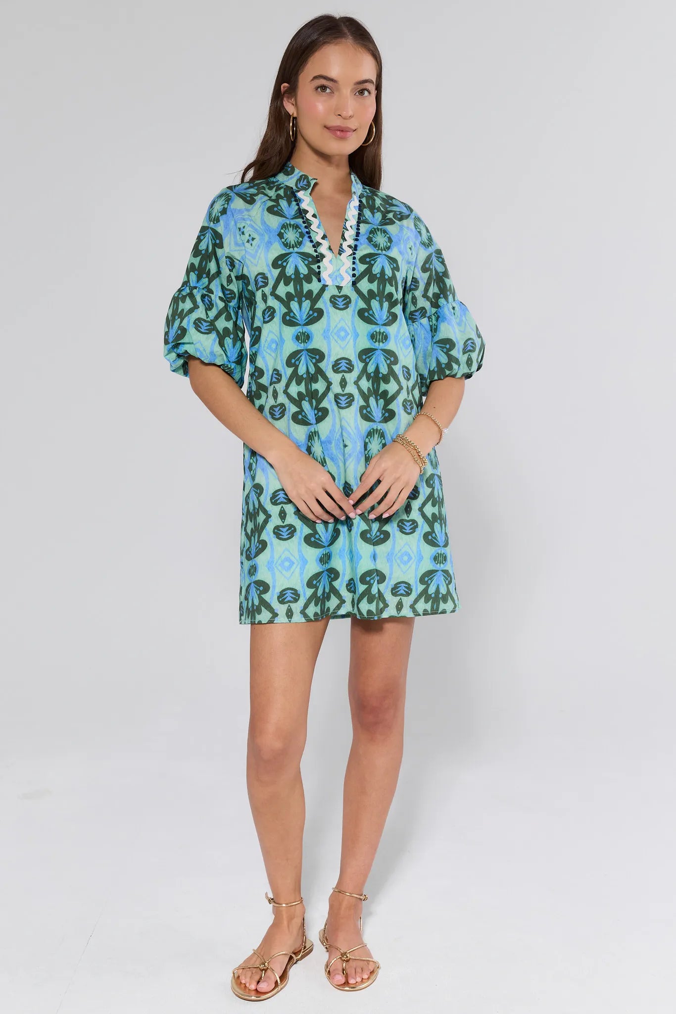 Woman wearing a blue and green patterned dress on white background