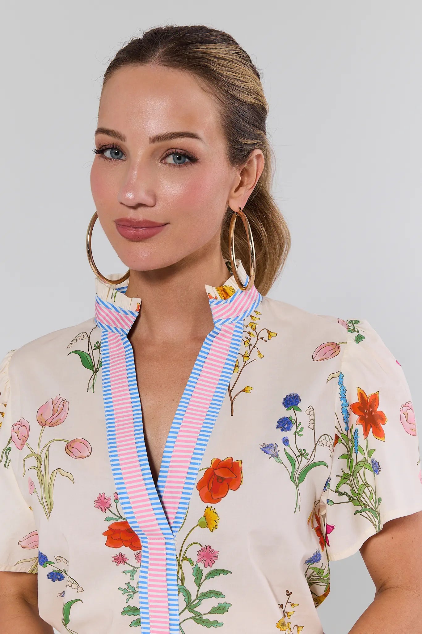 Woman wearing a floral blouse with a plain background