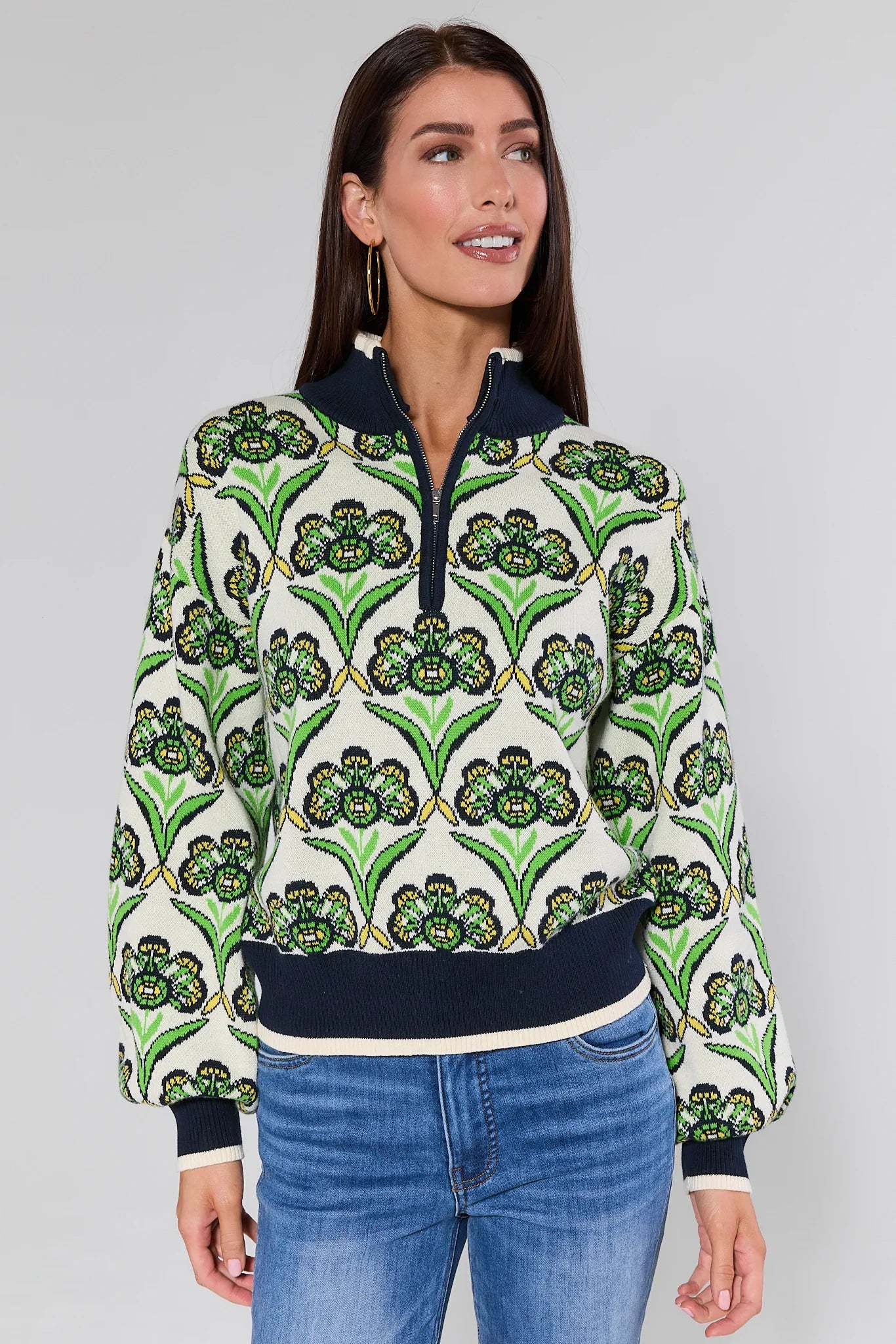Woman wearing a Andrea Green Half Zip Sweater with green floral design on a plain background