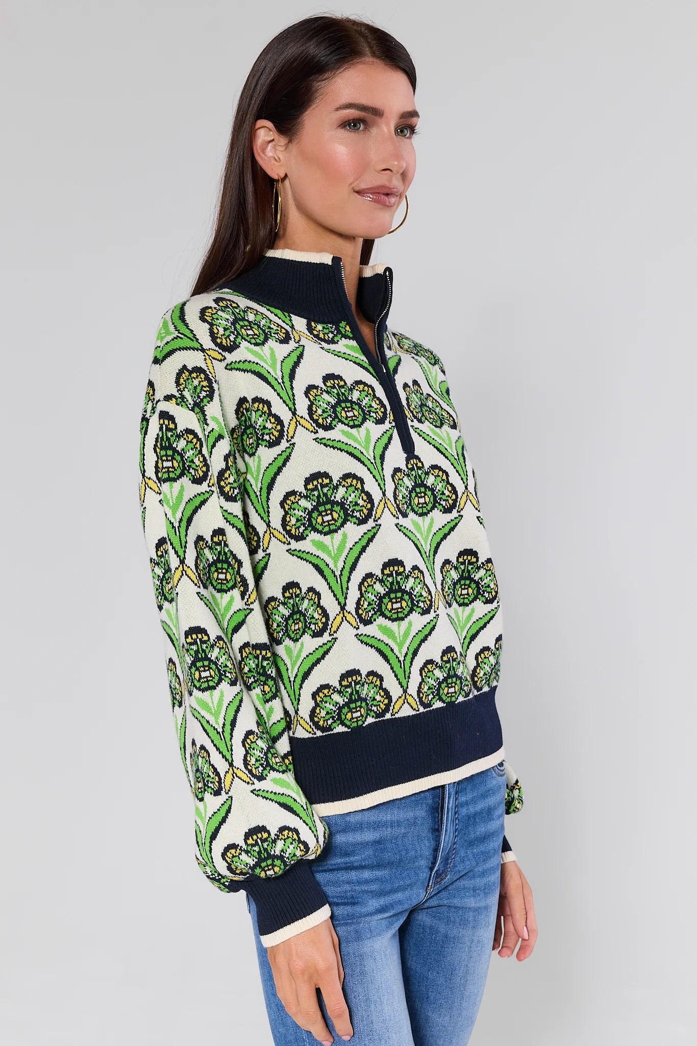 Woman wearing a Andrea Green Half Zip Sweater with green floral design on a plain background