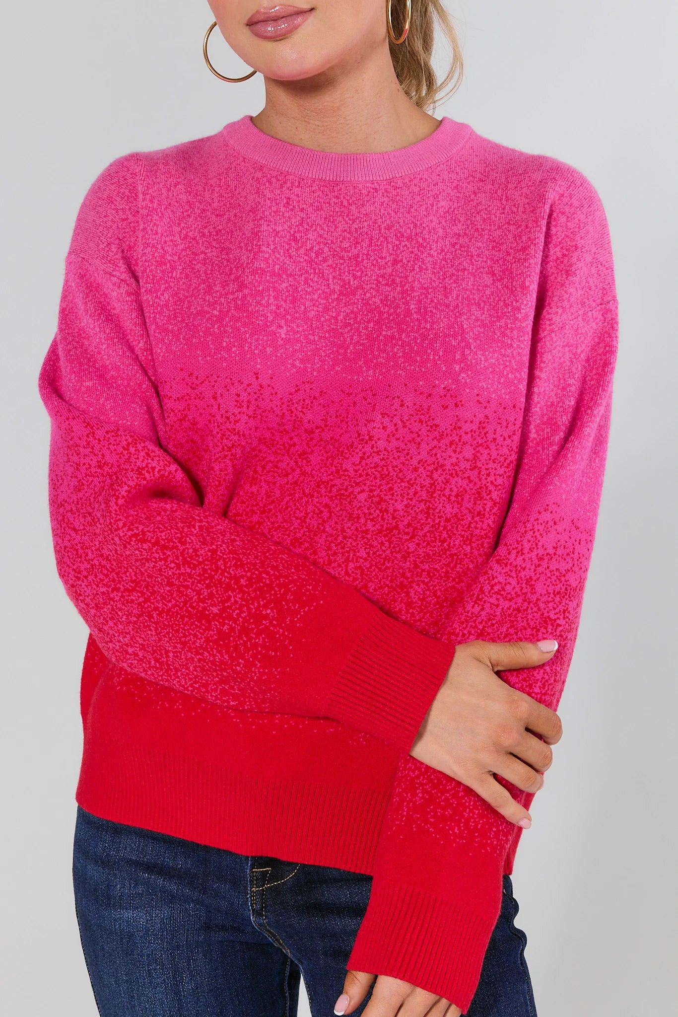 Woman wearing a Juliet Ombre Knit Sweater and blue jeans on a plain background