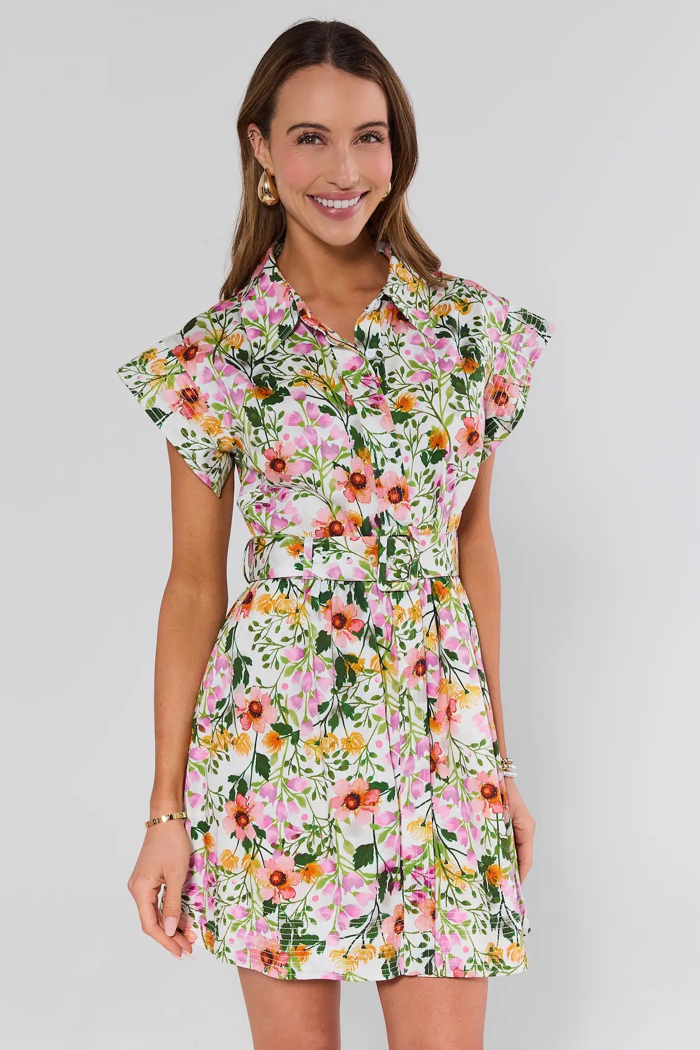 Woman wearing a floral elsie dress on a plain background