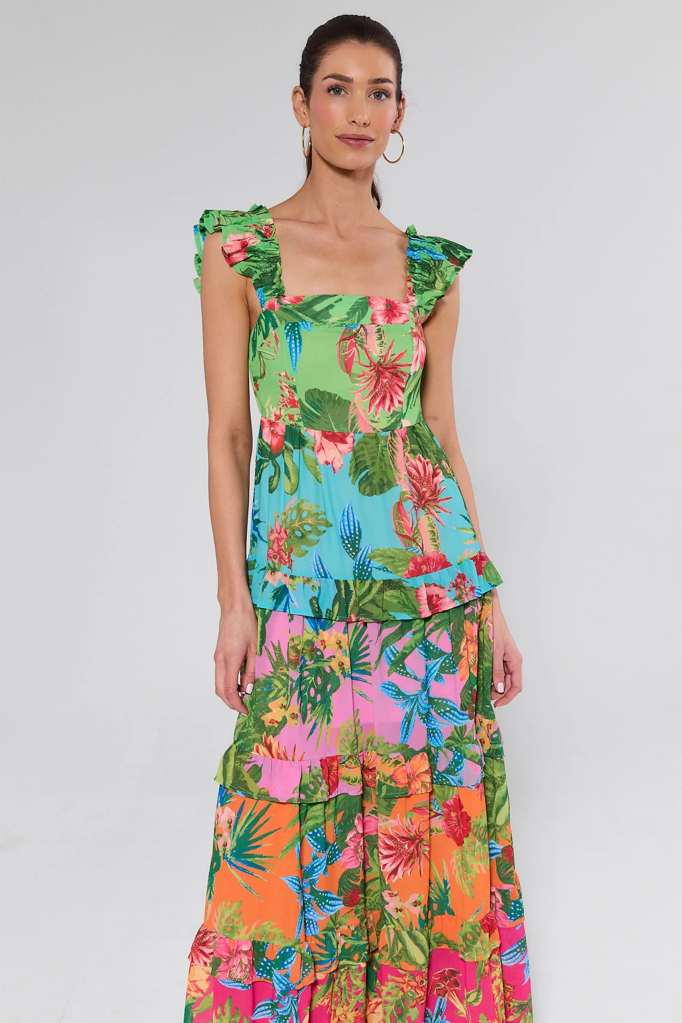 Woman wearing a colorful floral dress with a plain background