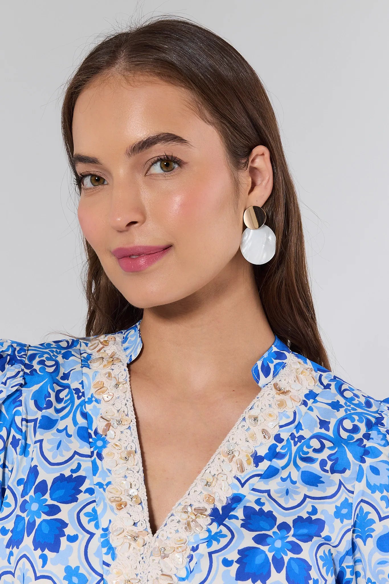Woman wearing a blue floral dress with a plain background
