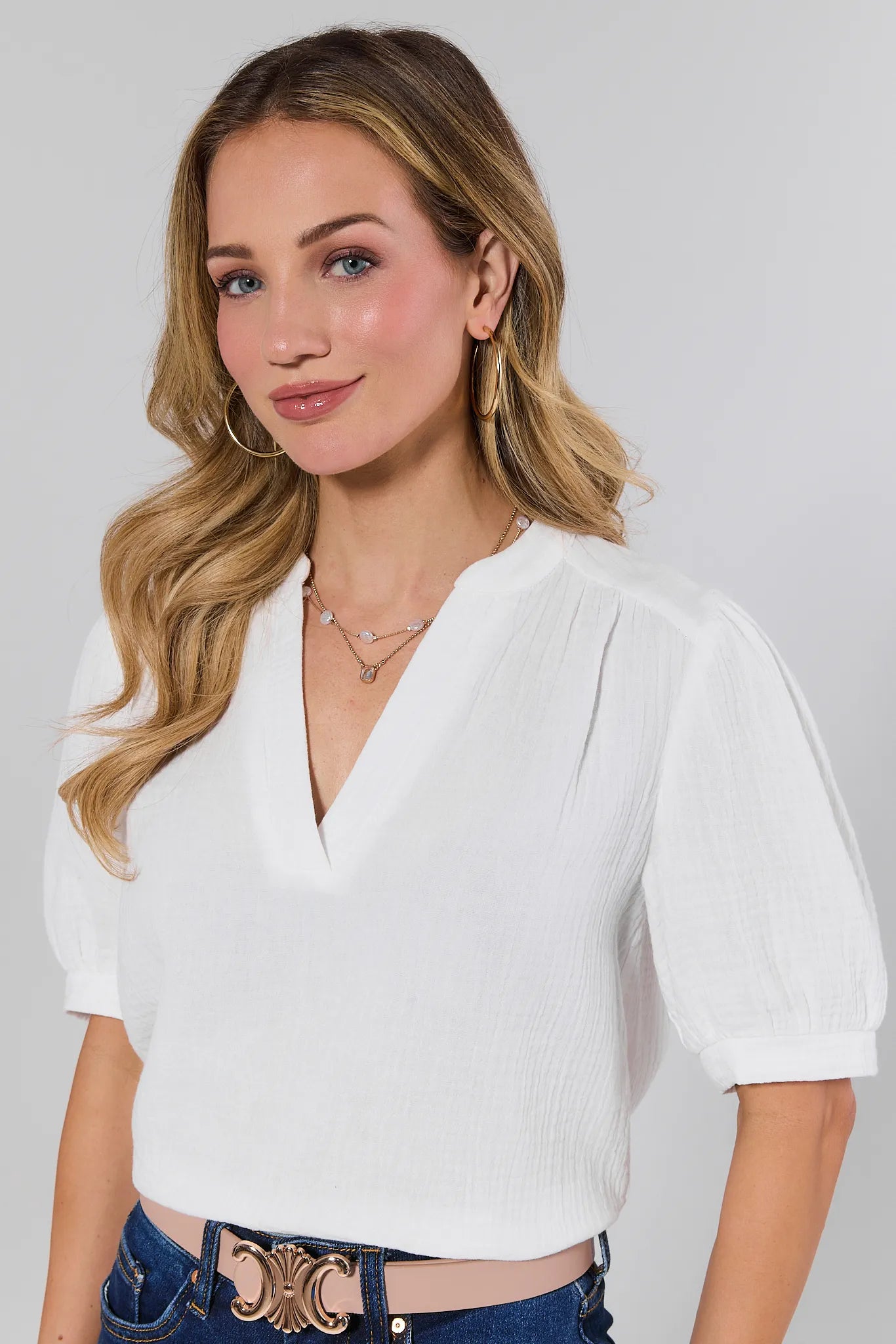 Woman wearing a white blouse with a plain background