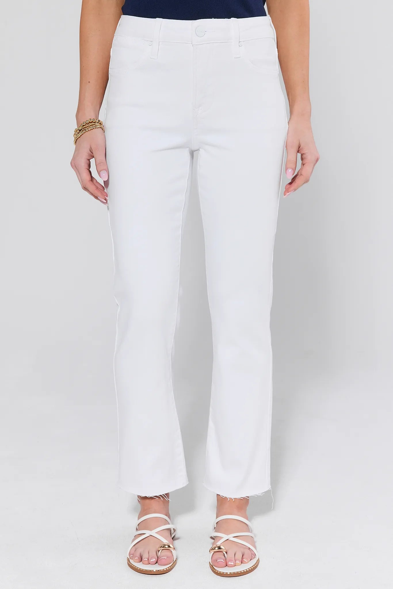 Person wearing white pants on a plain background