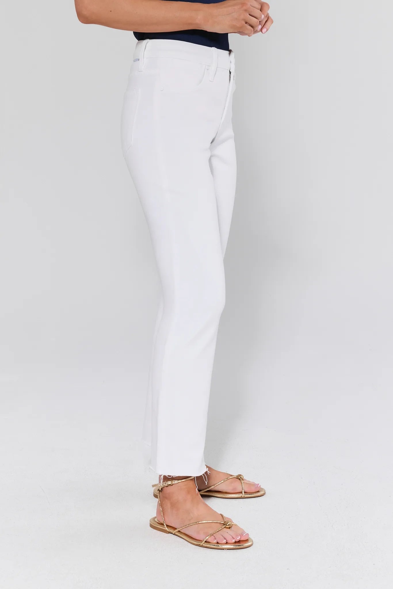 View 3: Person wearing white pants and gold sandals on a plain background
