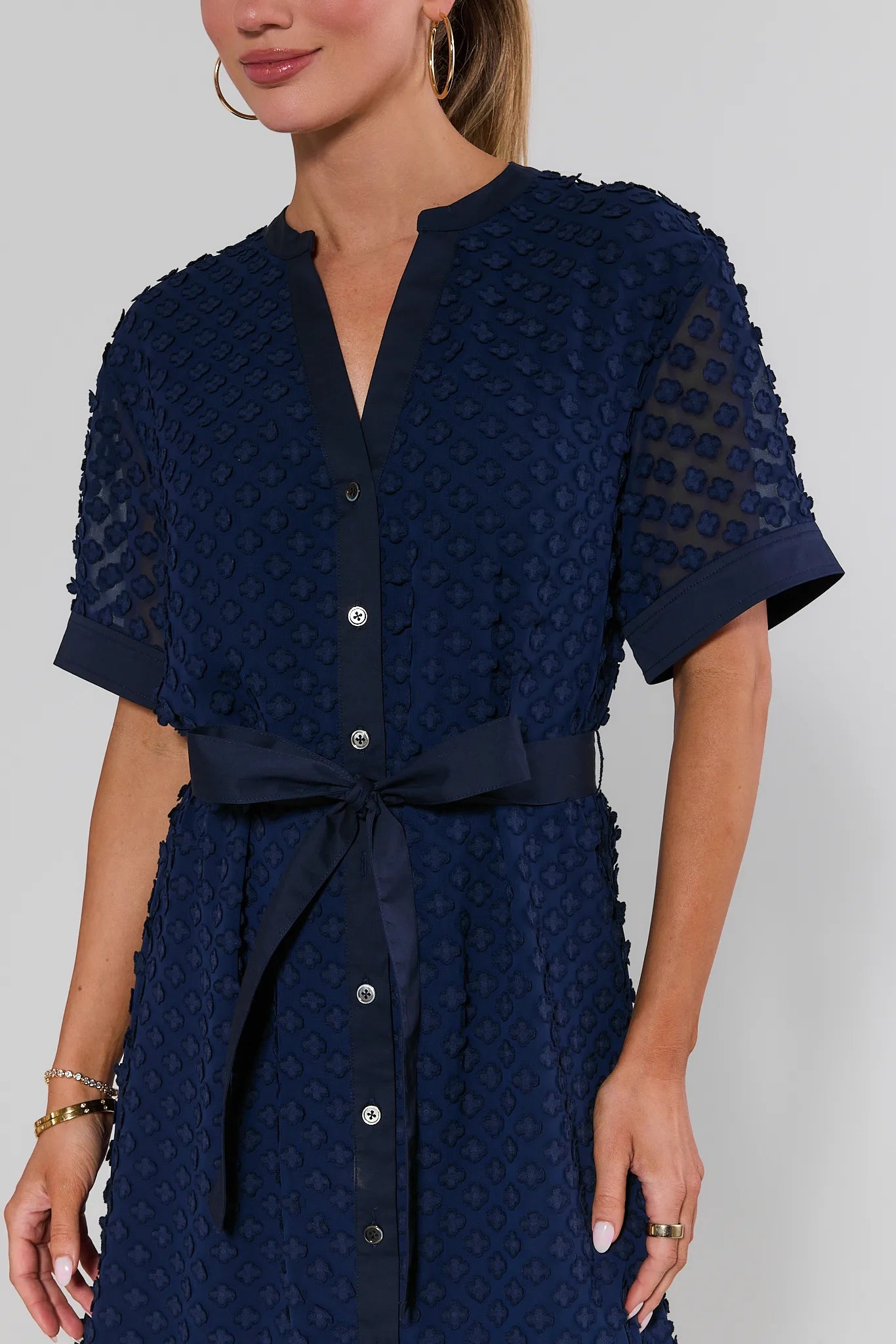 close up Navy blue dress with a textured pattern on a plain background