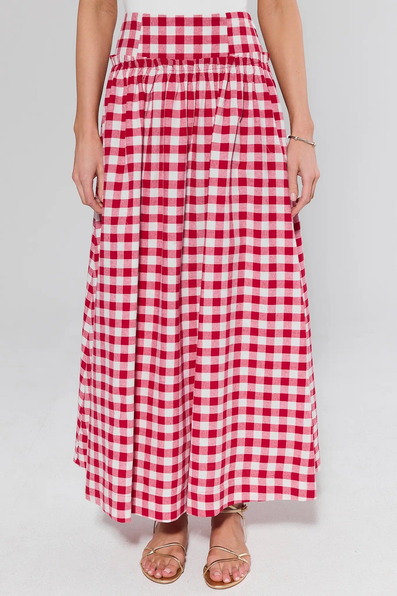 Red and white checkered skirt worn by a person on a plain background