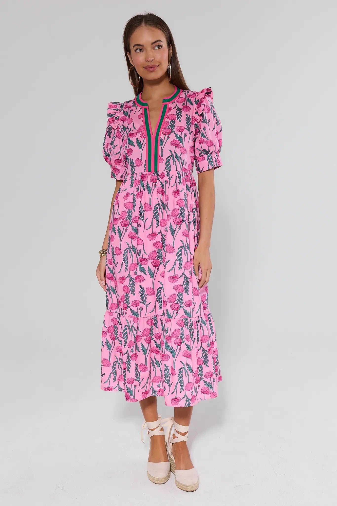 Woman wearing a pink floral dress on a light gray background