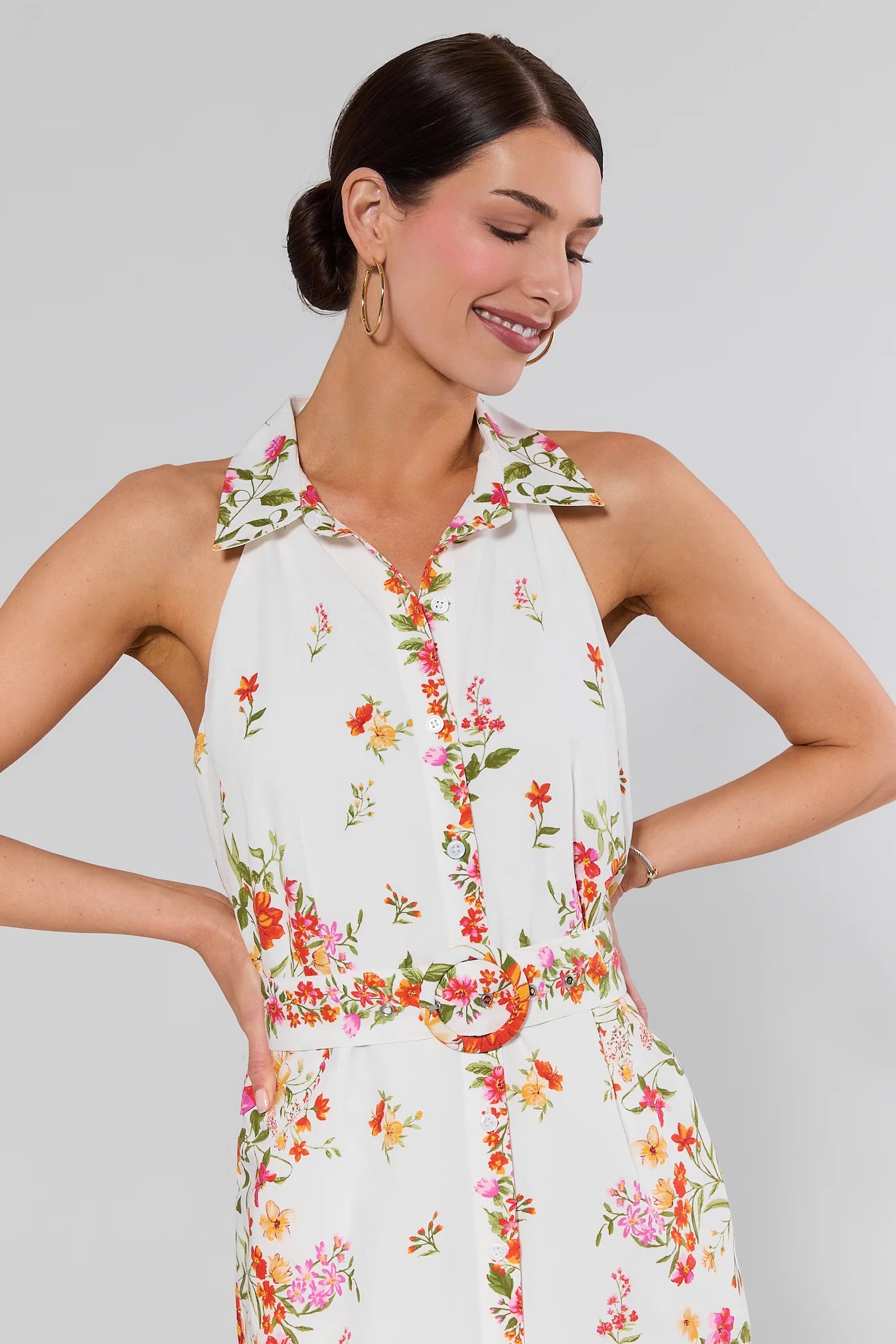 close up Woman wearing a floral jumpsuit against a gray background